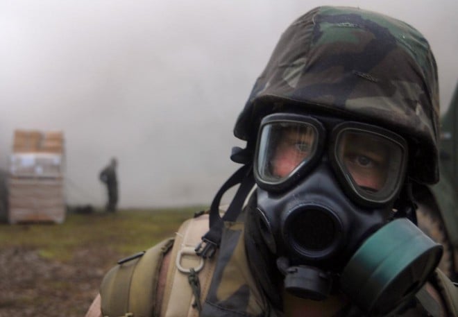 A sailor from the Naval Mobile Construction Battalion (NMCB) 11, adjusts his Mission Oriented Protective Posture (MOPP) gear during a simulated chemical agent attack during a field training exercise in 2008. U.S. Navy Photo