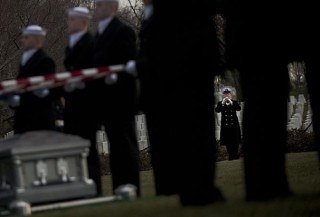A member of the U.S. Navy Ceremonial Guard plays "Taps" during a funeral at Arlington National Cemetery on March, 8. US Navy Photo