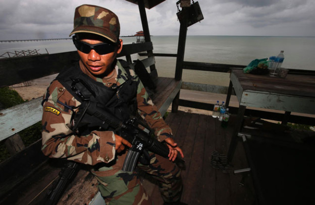 A Malaysian sailor stands guard on the beach near Lahad Datu. Reuters Photo 