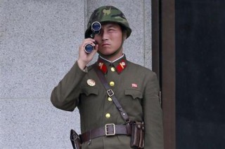 A North Korean soldier looks south through a pair of binoculars on the north side of the truce village of Panmunjom. Reuters Photo