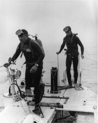 John Houchen, left, and N.D. Smith, SOS2(SS), on right, divers attached to the Trieste, going overboard to inspect the hull and attach equipment. Naval Institute Archives