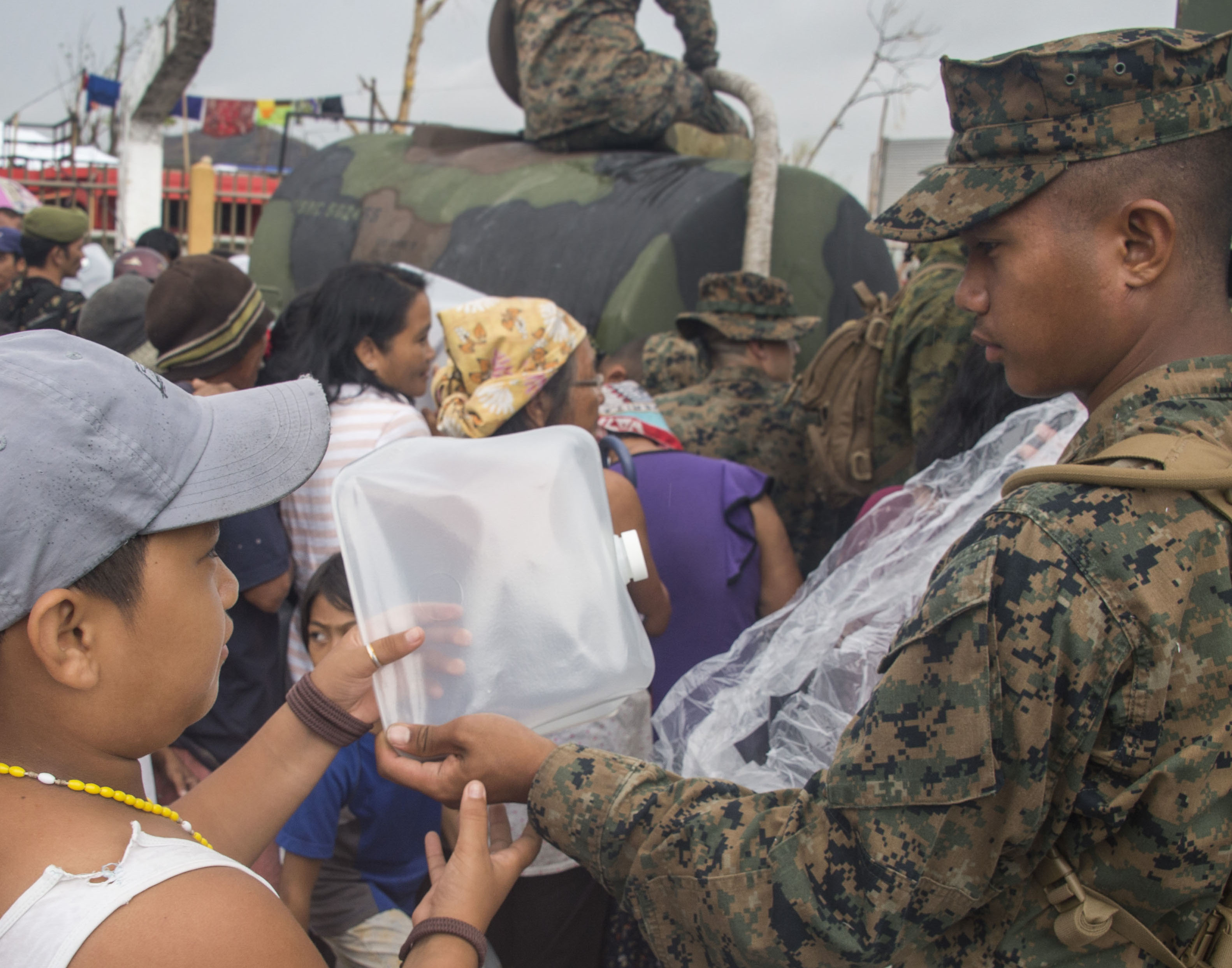 U.S. Marine Pfc. John Evans assigned to Combat Logistics Battalion 4 (CLB 4) distributes water on Nov. 23, 2013 to Palo residents affected by Typhoon Haiyan. US Navy Photo