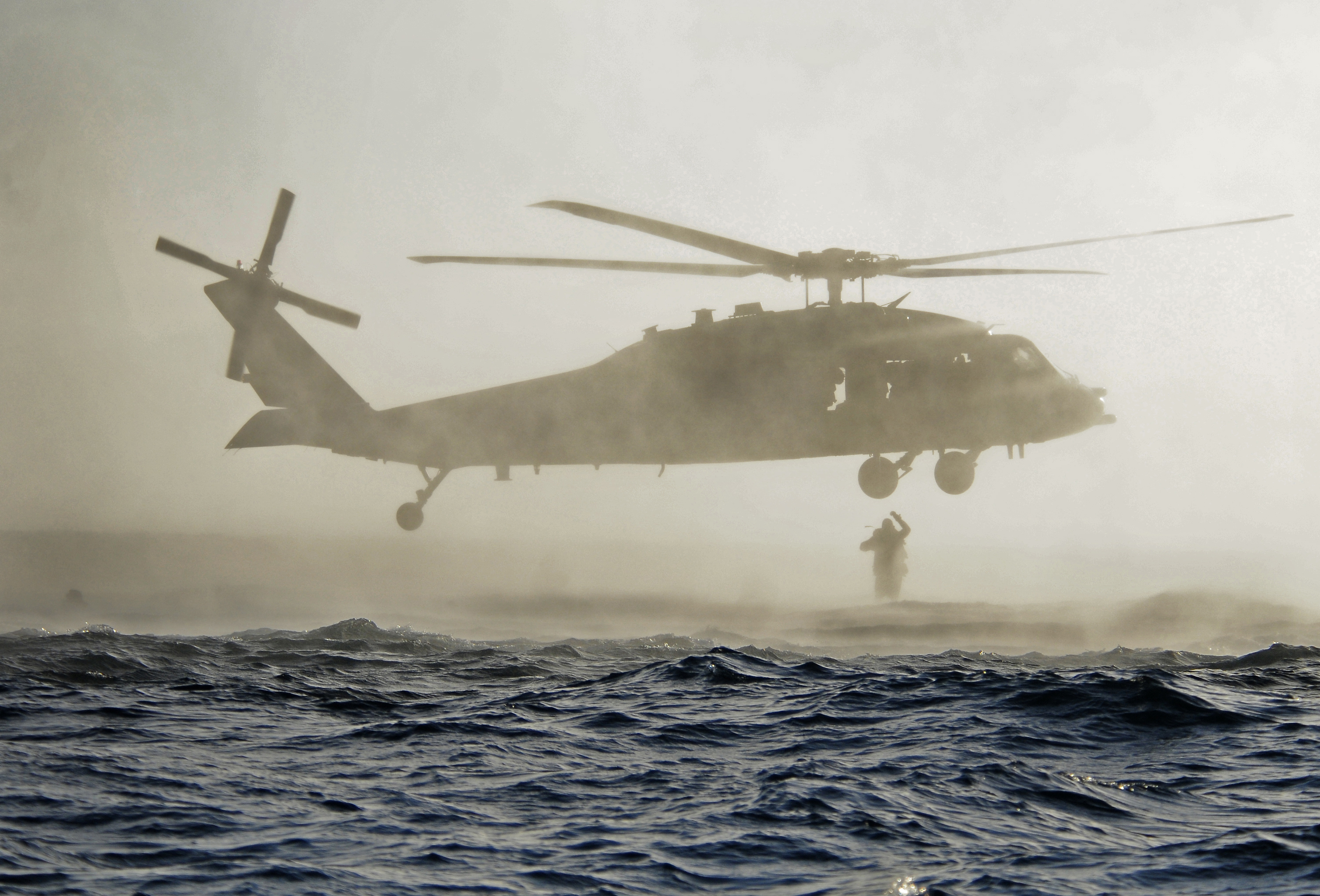 US Navy SEALs jump out of an SH-60 Sea Hawk helicopter during a combat rescue swimmer course. US Navy Photo