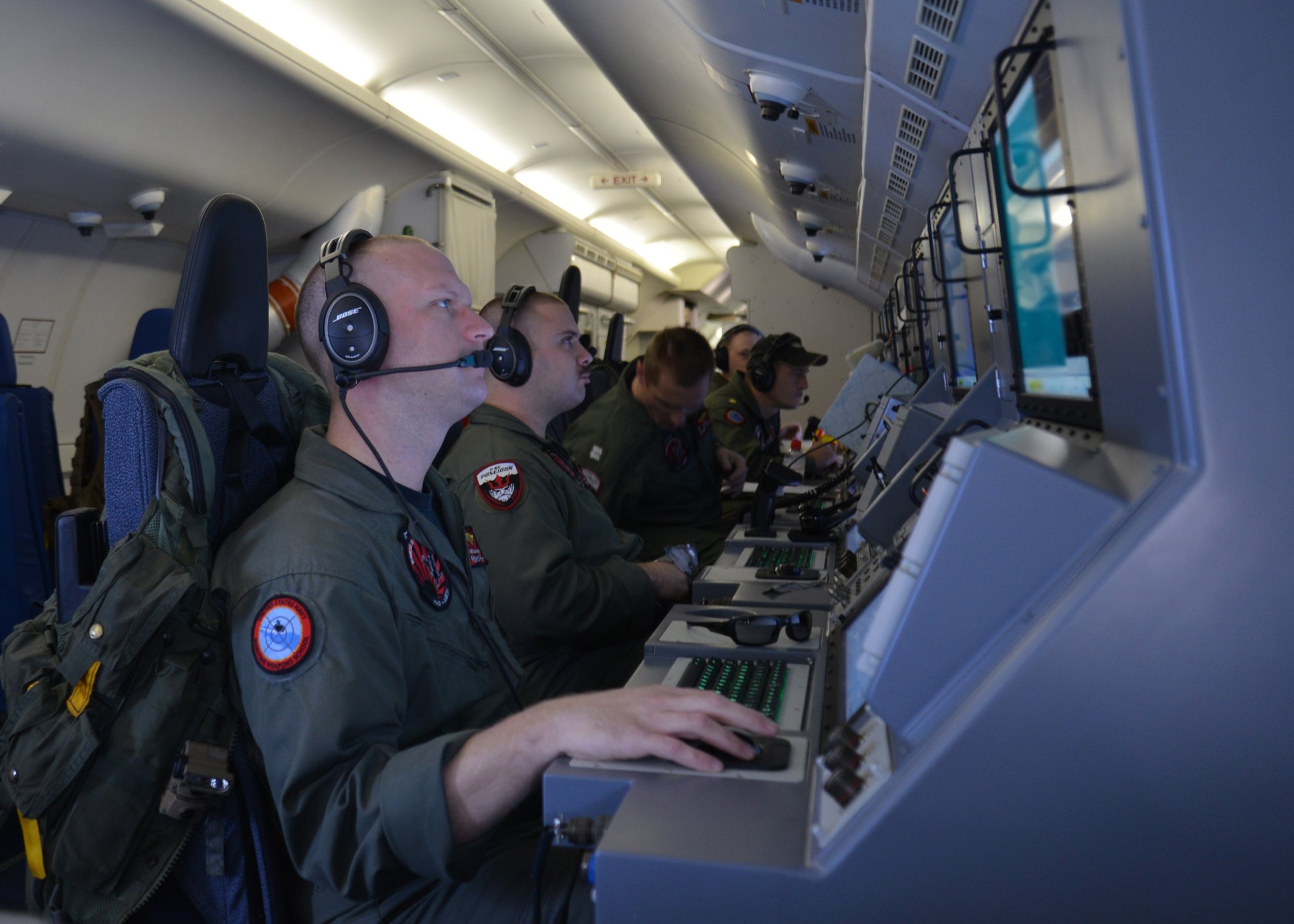 Crew members on board a P-8A Poseidon assigned to Patrol Squadron (VP) 16 man their workstations while assisting in search and rescue operations for Malaysia Airlines flight MH370 on March, 16 2014. US Navy Photo