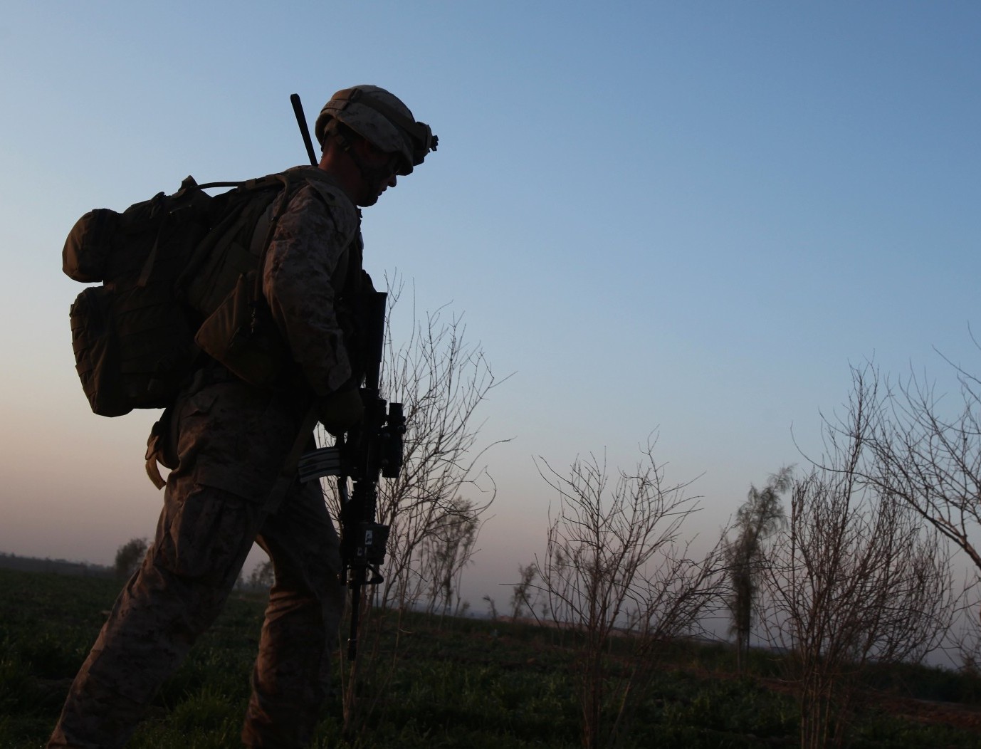 An infantry Marine with 3rd Platoon, Charlie Company, 1st Battalion, 9th Marine Regiment, walks across a field during a security patrol in Helmand province, Afghanistan, Feb. 20, 2014. US Marine Corps Photo