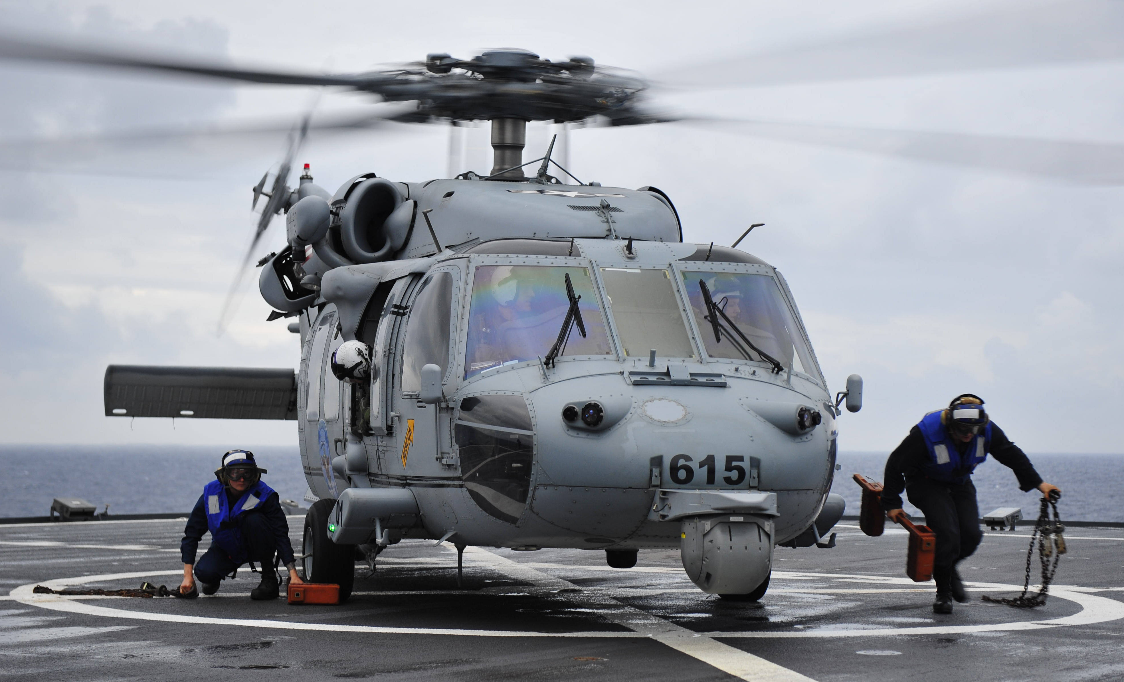 Sailors remove chocks and chains from beneath a MH-60S Knighthawk on USS Blue Ridge (LCC-19) on May 3, 2014. US Navy Photo