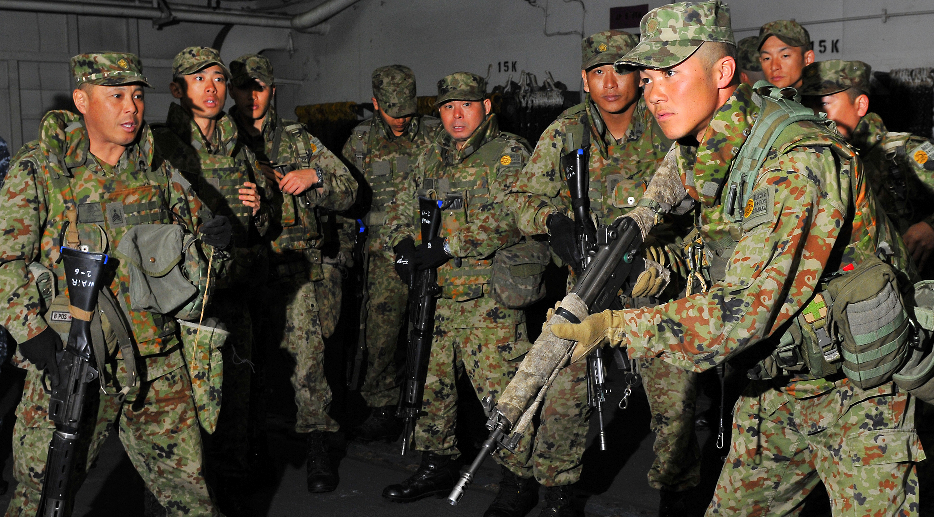 Japan Ground Self-Defense Force conduct small arms weapons training aboard the amphibious assault ship USS Peleliu (LHA-5) in 2012. US Navy Photo