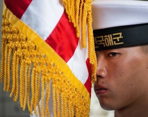 Republic of Korea Navy sailor holding U.S. flag