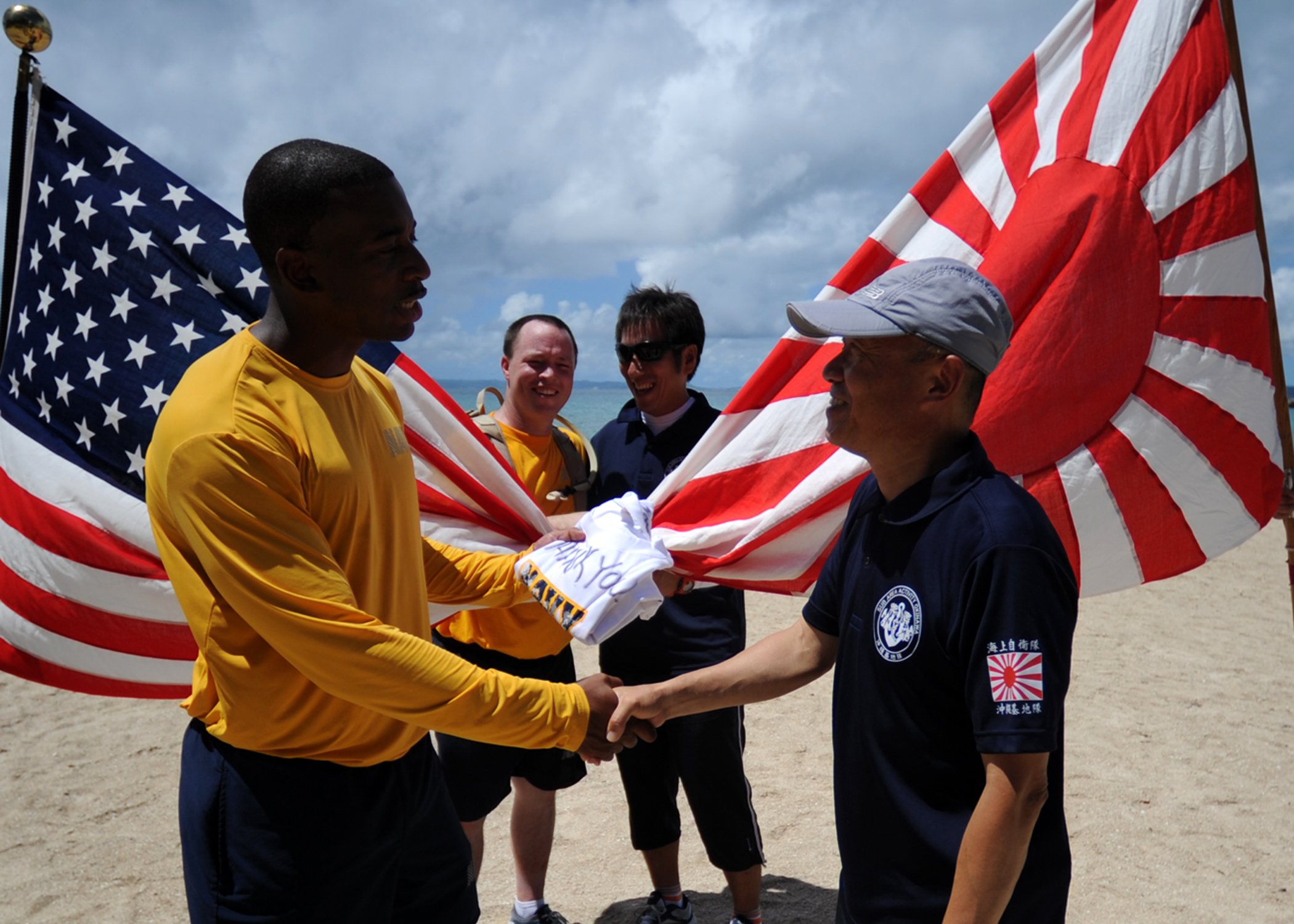 Engineering Aide 1st Class Willie Blanding presents a gift to Capt. Masahito Inoue, commanding officer of Japan Maritime Self-Defense Force (JMSDF) Sub Area Activity, Okinawa in 2013. US Navy Photo