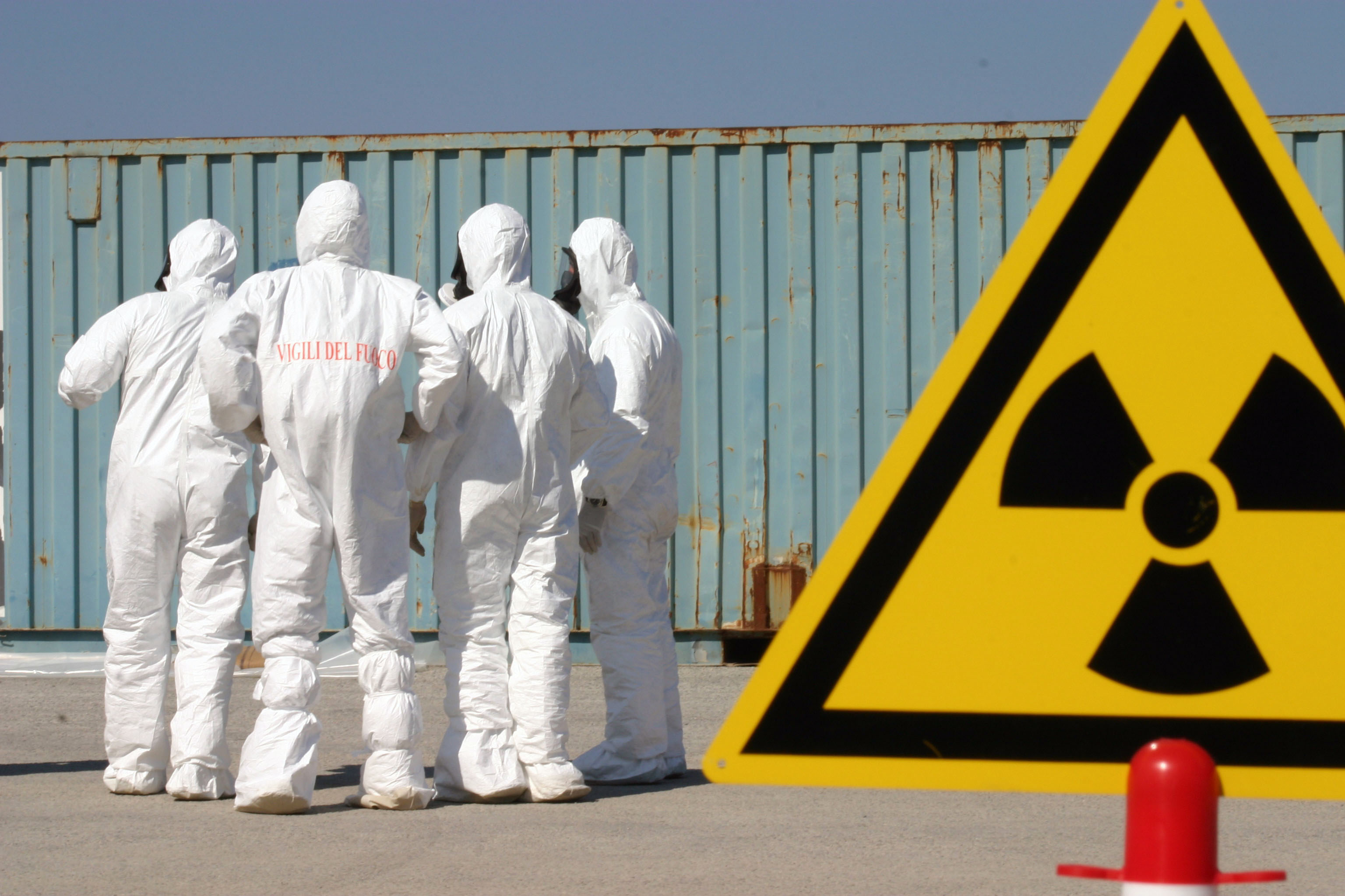  Italian firefighters dressed in chemical, biological, radiological (CBR) suits set up a perimeter of signs around a container suspected of carrying weapons of mass destruction (WMD) during a US led exercise in 2004. US Navy Photo 