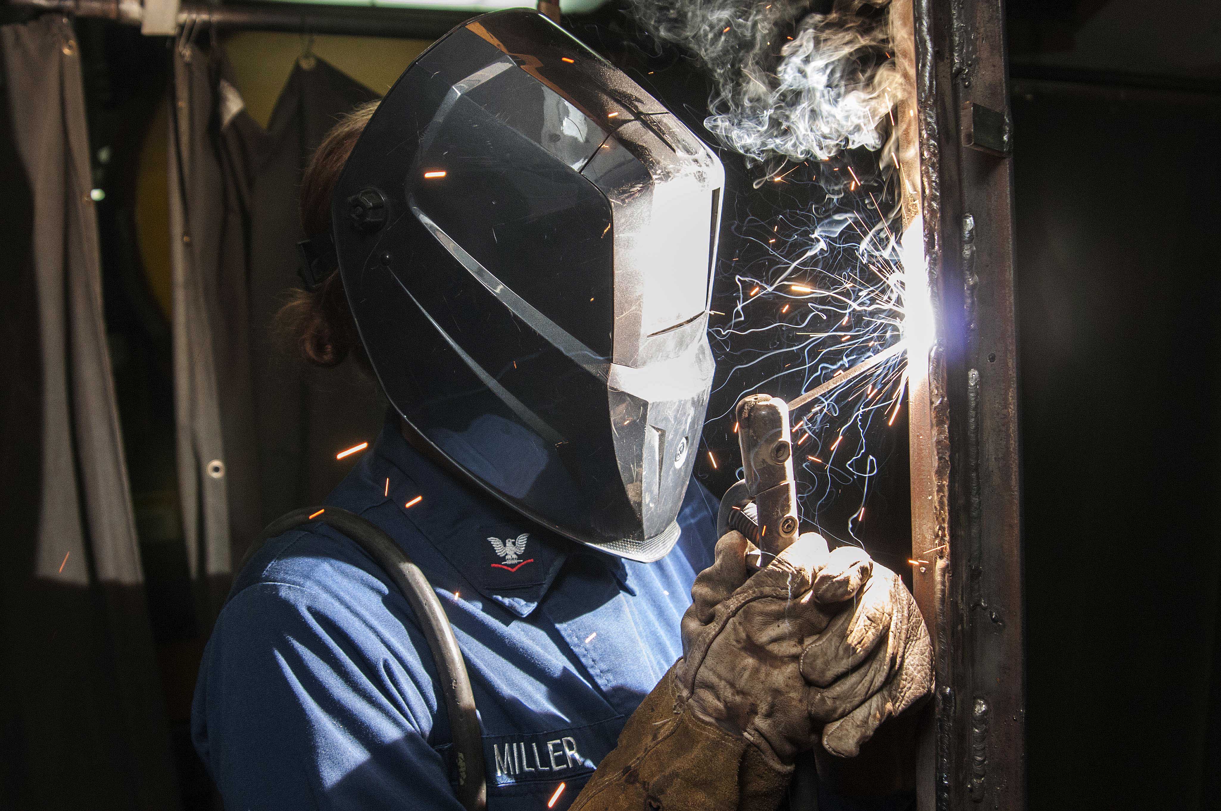 A sailor welds during the ongoing maintinance availability for carrier USS Dwight D. Eisenhower (CVN-69) on June 26, 2014. US Navy Photo 