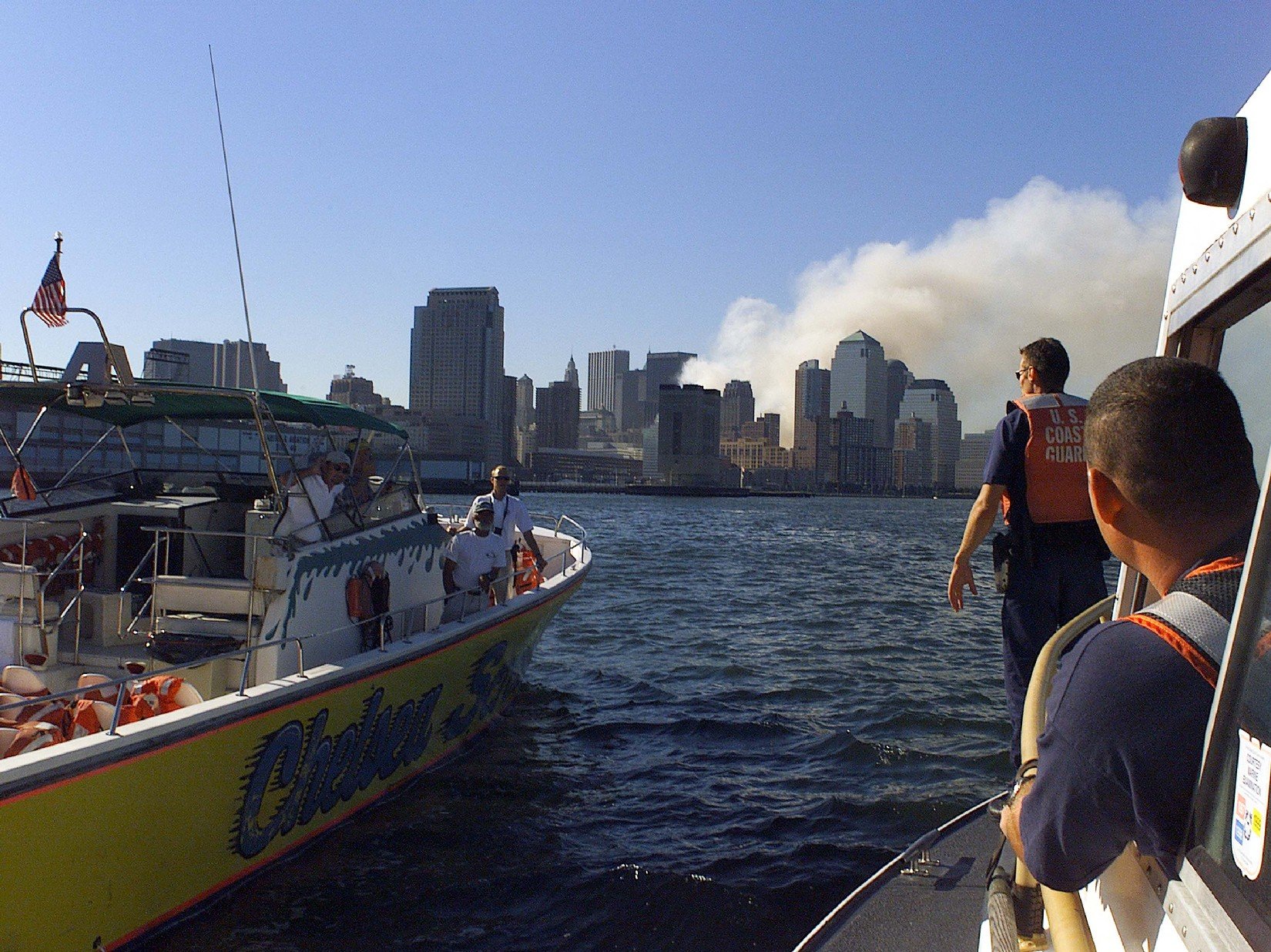 <em>A Coast Guard and private vessel approach Manhattan following the collapse of the Twin Towers (U.S. Coast Guard)</em>