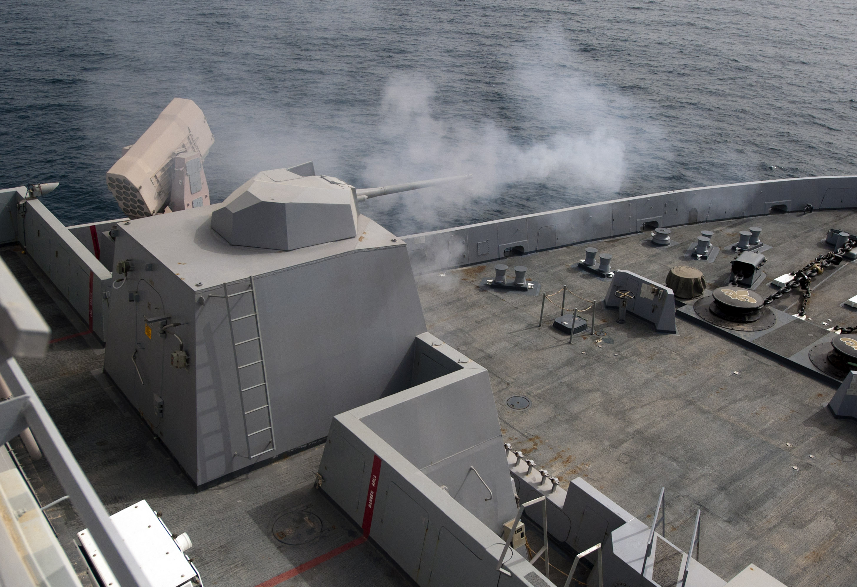 he MK46 Mod 1 weapon system fires a round during a live-fire qualification exercise aboard the amphibious transport dock ship USS New Orleans (LPD-18). US NAvy Photo