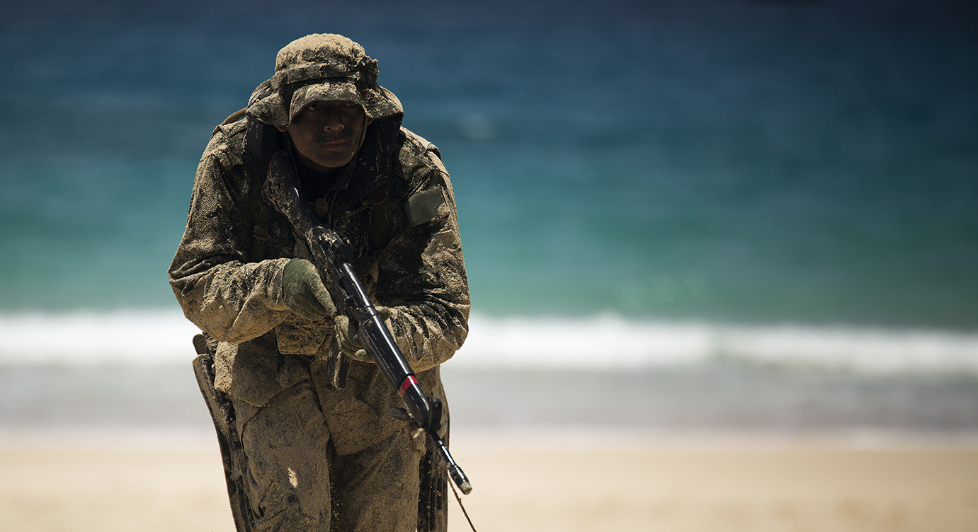 Japan Ground Self-Defense Force (JGSDF) soldier advances positions while his squad member provides cover during an amphibious assault at Pyramid Rock Beach on July 1, 2014. US Navy Photo