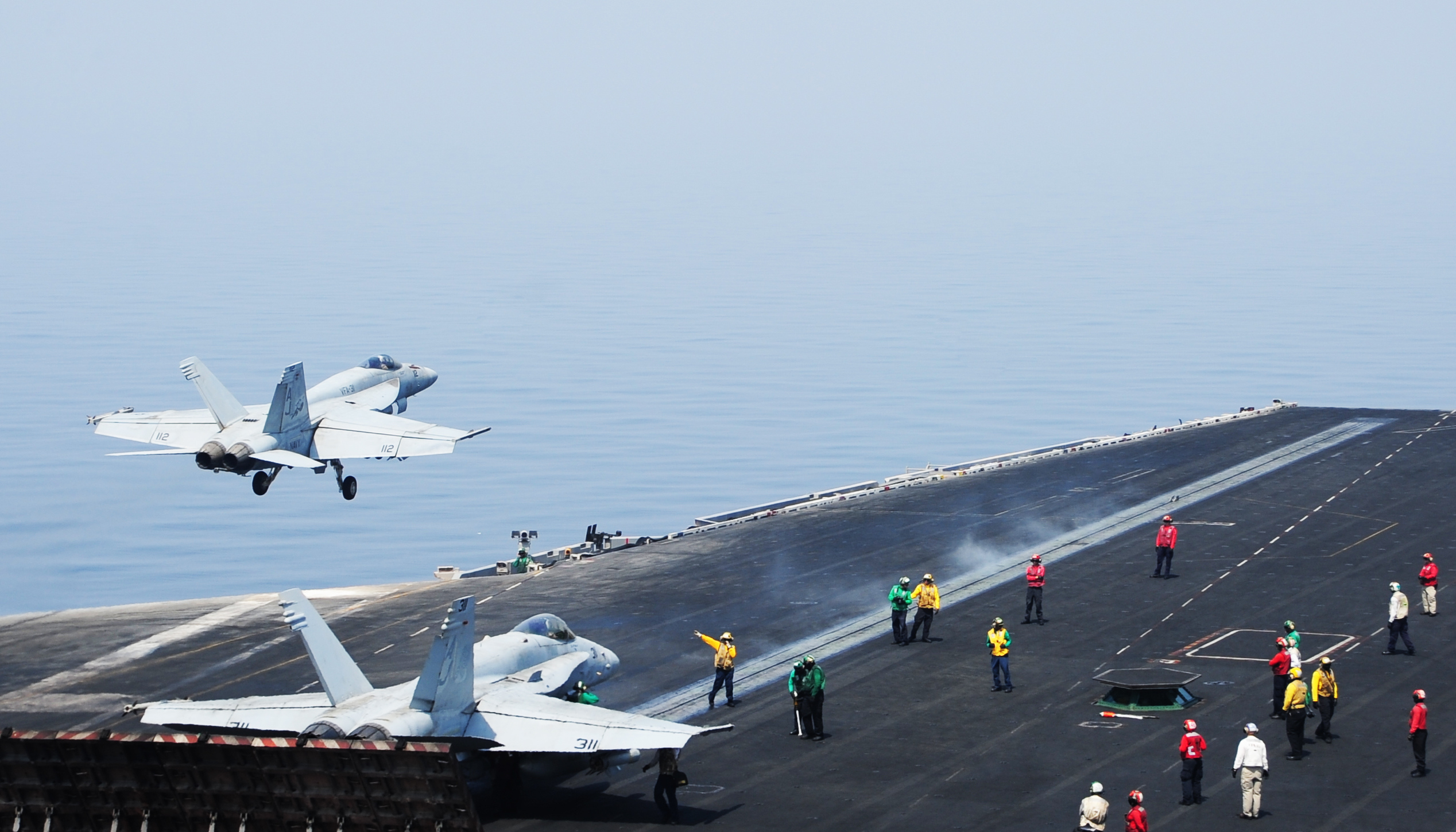Sailors direct aircraft as an F/A-18E Super Hornet attached to the Tomcatters of Strike Fighter Squadron (VFA) 31 takes off from the flight deck of the aircraft carrier USS George H.W. Bush (CVN-77). US Navy Photo
