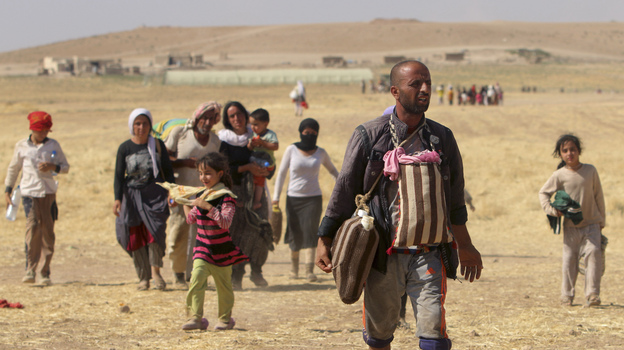 Displaced people from the minority Yazidi sect walk toward the Syrian border on the outskirts of Sinjar mountain on Aug. 11. Reuters Photo