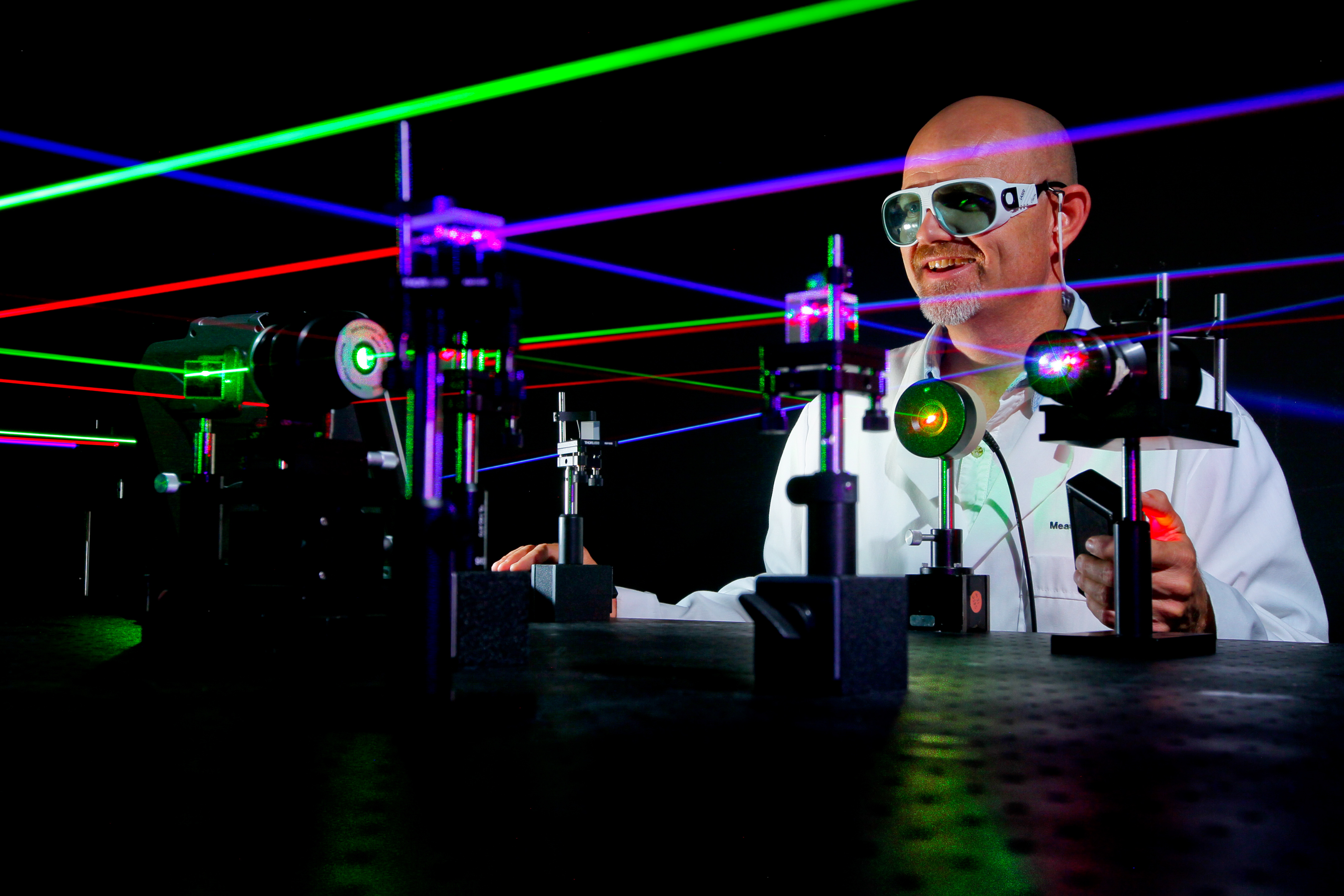 A microwave/electro-optic (MS32) electronics engineer at Naval Surface Warfare Center (NSWC), Corona Division, uses visible lasers to align various optical components on Aug. 29, 2014. US Navy Photo