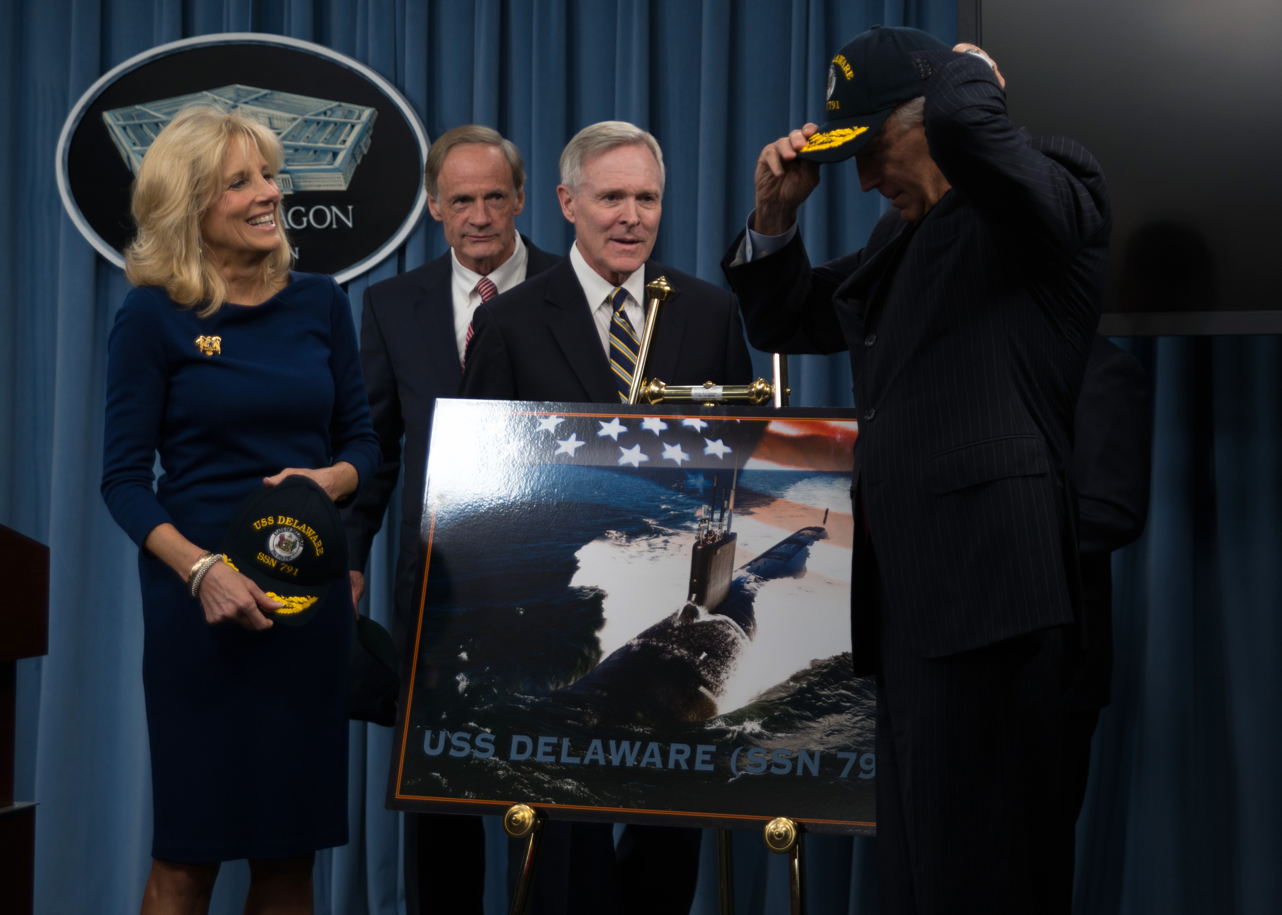 Secretary of the Navy Ray Mabus and ship's sponsor, Dr. Jill Biden, watch as Vice President Joe Biden puts on a USS Delaware ball cap at the Pentagon announcing the name the future Virginia-class attack submarine USS Delaware (SSN 791) on Nov. 19, 2012. US Navy Photo