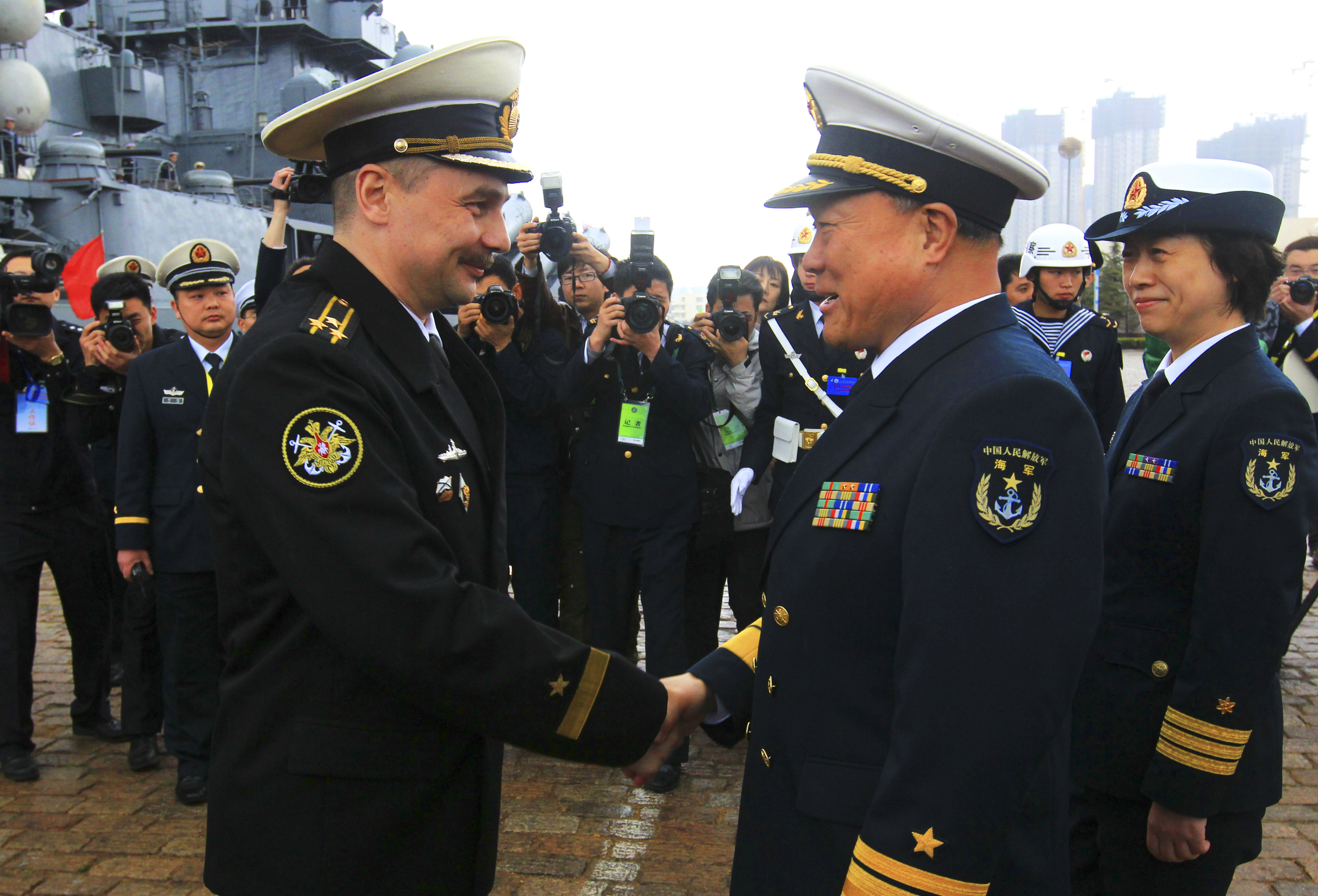 Rear Adm. Du Xiping (front right), deputy commander of China's Beihai Fleet, shakes hands with Capt. 1st Rank Sergei Yuriyevich Zhuga of Russia's Pacific Fleet during a welcome ceremony at a naval base in Qingdao, in east China's Shandong Province, on April 21, 2012. Xinhua Photo 