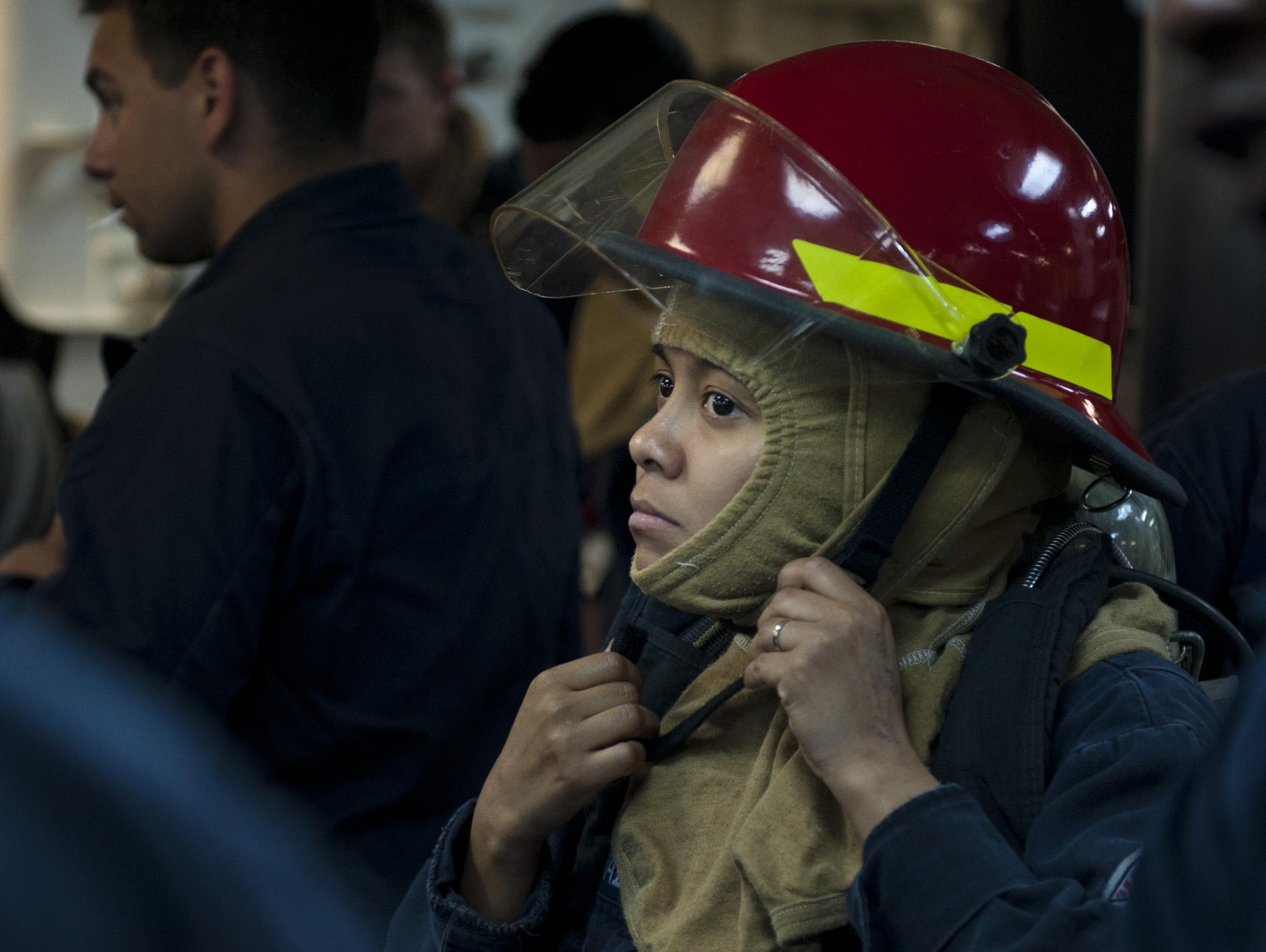 Gas Turbine System Technician (Electrical) 2nd Class Rosa Moran Vazquez puts on her firefighting gear during a general quarters drill on USS Arleigh Burke (DDG-51) on April 11, 2014. US Navy Photo