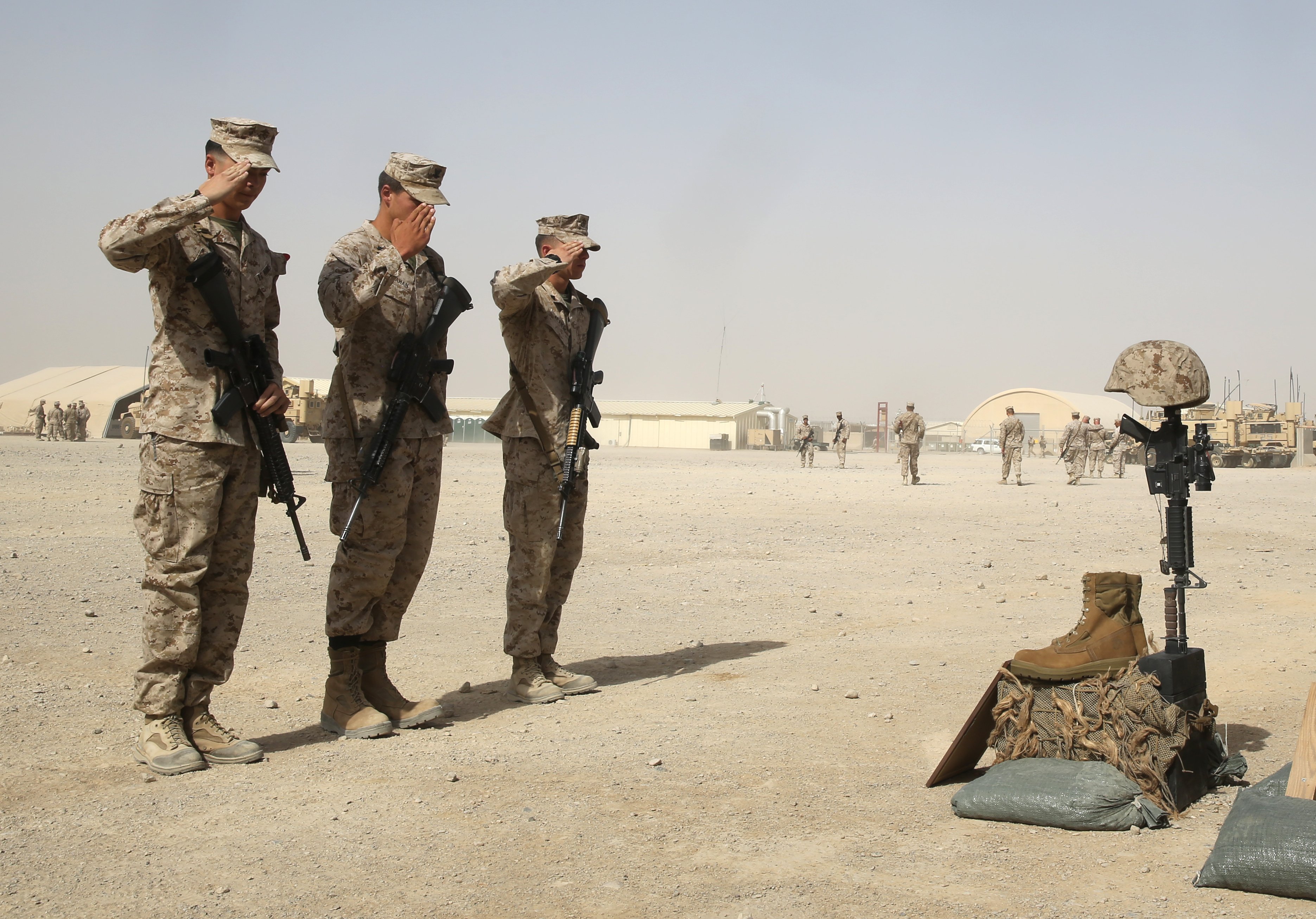 Marines with 1st Battalion, 7th Marine Regiment, salute a battlefield cross during a memorial ceremony aboard Camp Leatherneck, July 2, 2014. US Marine Corps Photo