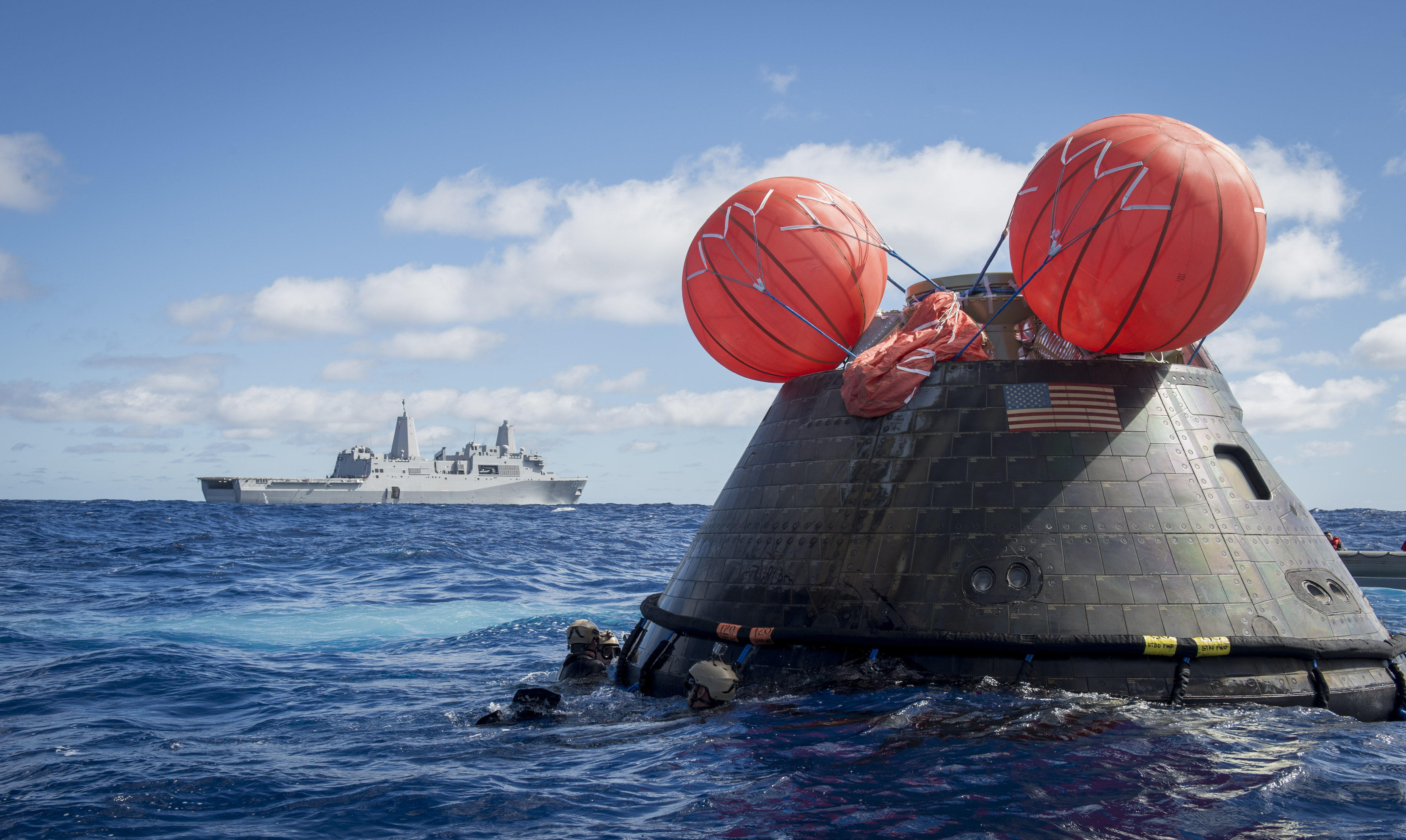 Navy divers assigned to Explosive Ordnance Disposal Mobile Unit (EODMU) 11 and Mobile Diving and Salvage Company 11‐7, attach a towing bridle to the NASA Orion crew module on Dec. 5, 2014. US Navy Photo