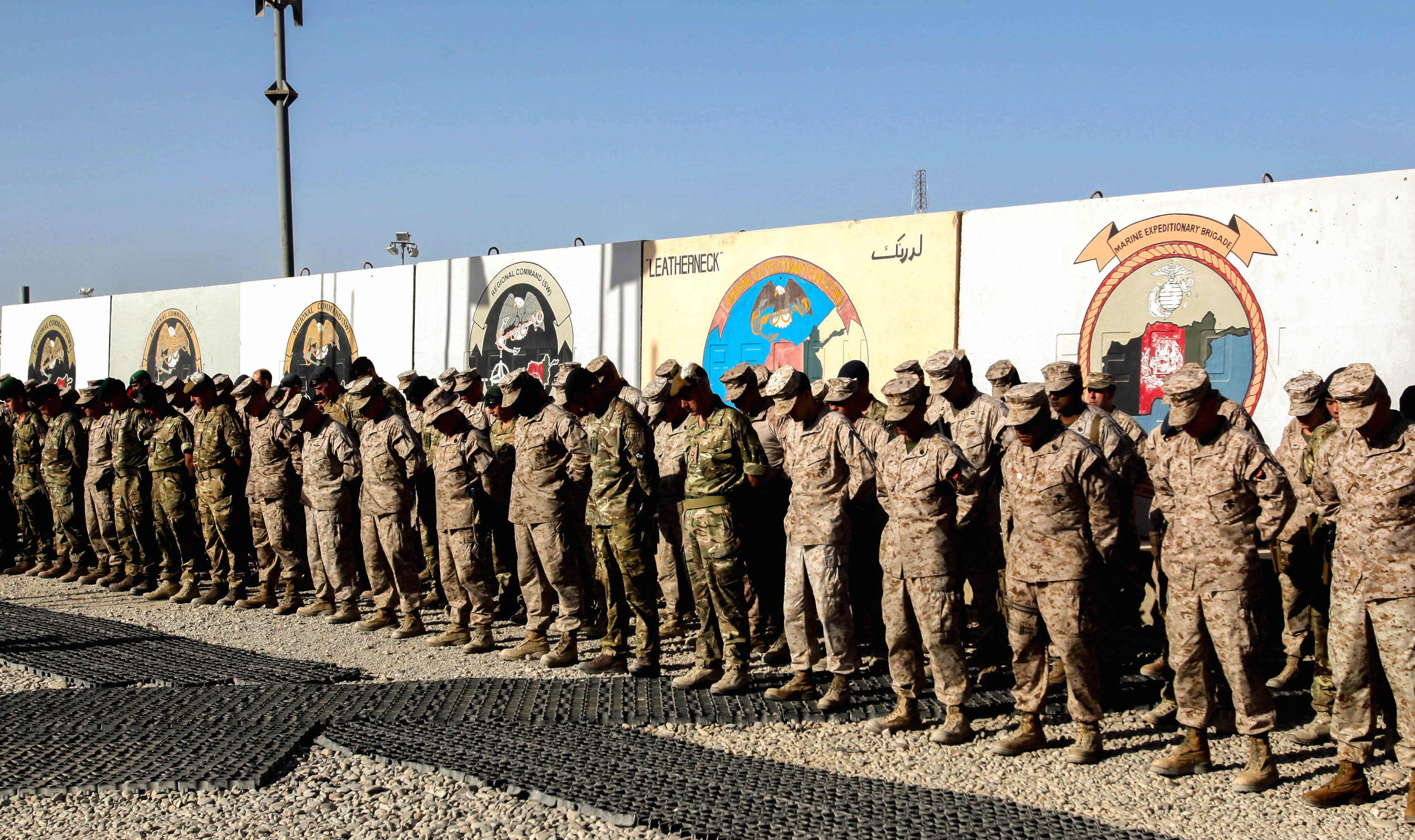 Marines, sailors and coalition partners with Regional Command (Southwest) bow their heads during a moment of silence at the 9/11 memorial ceremony aboard Camp Leatherneck, Afghanistan, Sept. 11, 2014. US Marine Corps Photo