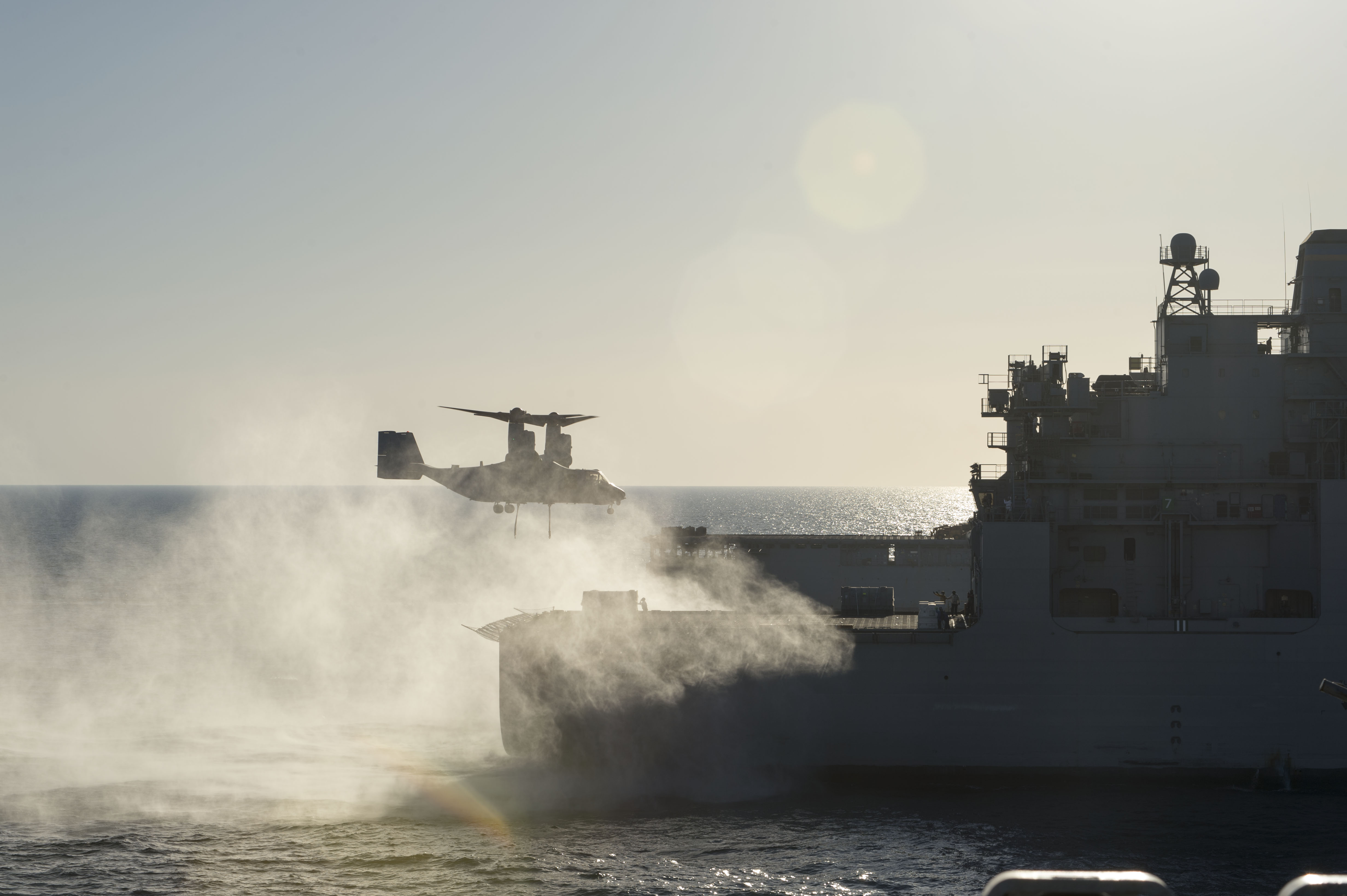 An MV-22 Osprey assigned to Marine Medium Tiltrotor Squadron (VMM) 163, Reinforced, approaches the Military Sealift Command dry cargo and ammunition ship USNS Robert E. Peary (T-AKE 5) to transport an AV-8B Harrier jet engine to the amphibious assault ship USS Makin Island (LHD 8) during a replenishment-at-sea in October 2014. US Navy photo.