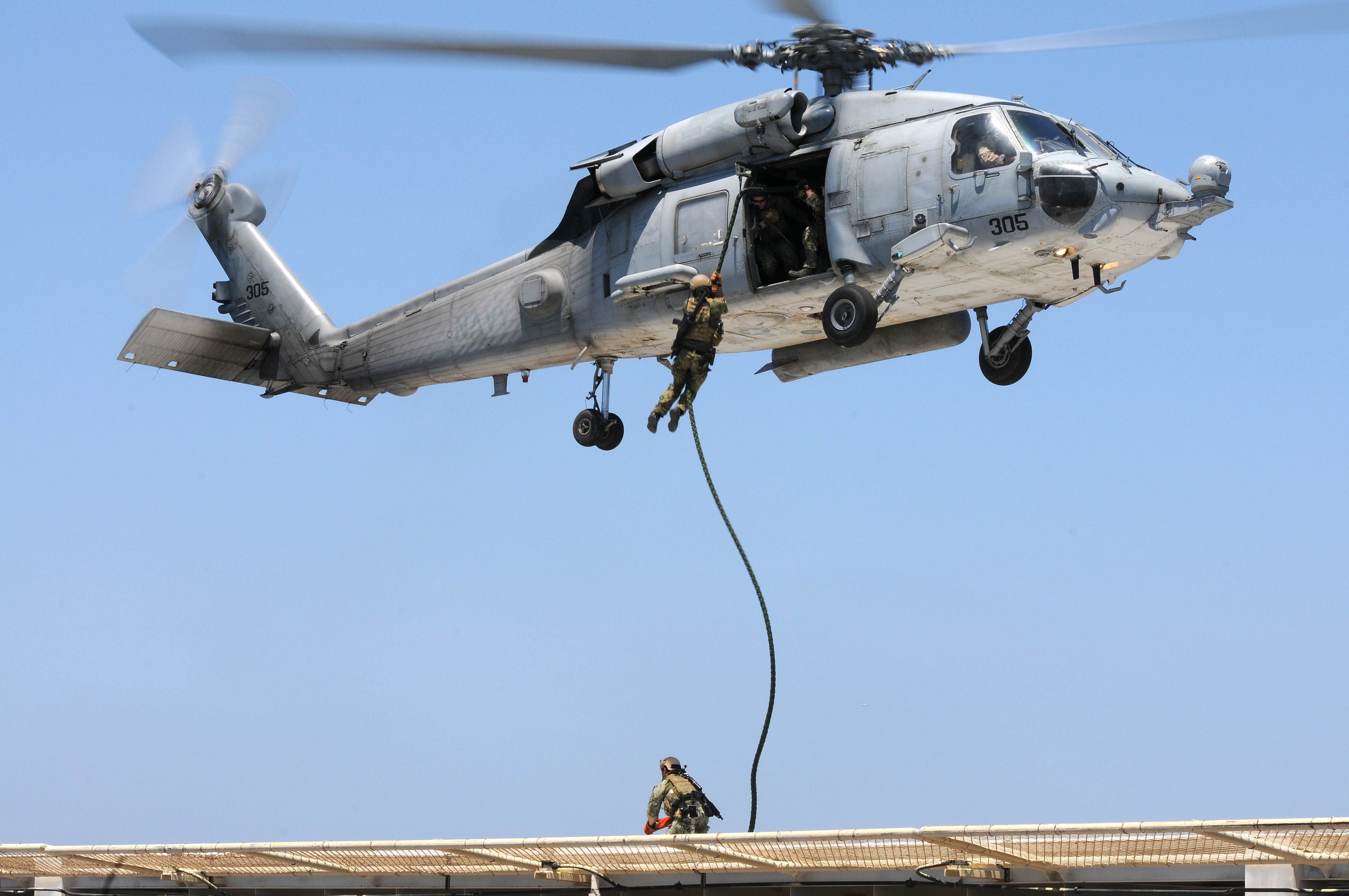 A U.S. Navy SEAL fast ropes from an HH-60H Sea Hawk helicopter assigned to the High Rollers of Helicopter Sea Combat Squadron (HSC) 85 onto a gas and oil platform in July 2011. US Navy photo.