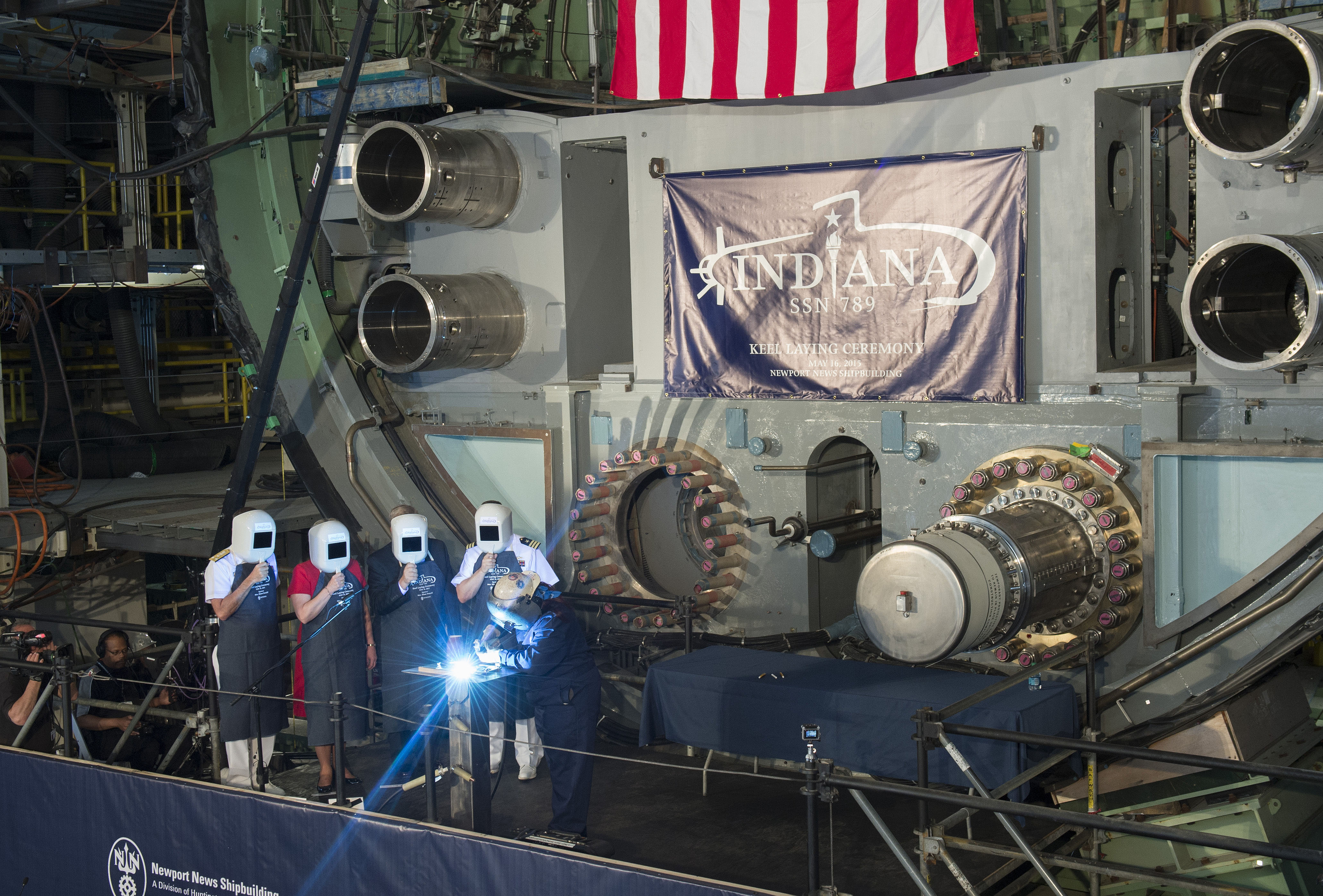 A welder carves the initials of ship's sponsor Diane Donald on a metal plate during the keel laying ceremony for the future Virginia-class attack submarine Indiana (SSN 789) on May 16, 2015. US Navy photo courtesy of Huntington Ingalls Industries.