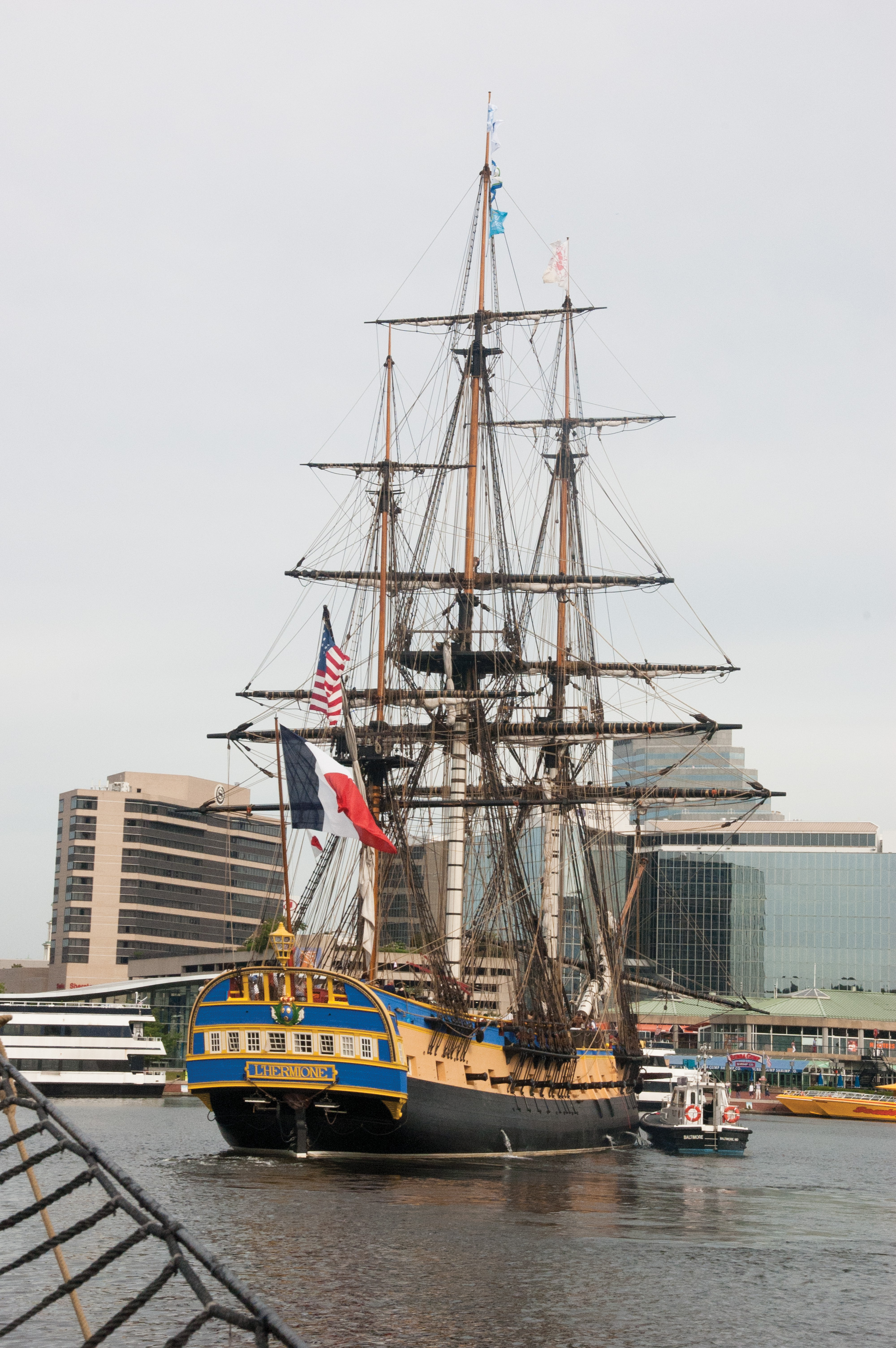 Tugs guide the replica Hermione into its pier at Baltimore's Inner Harbor. USNI News photo.