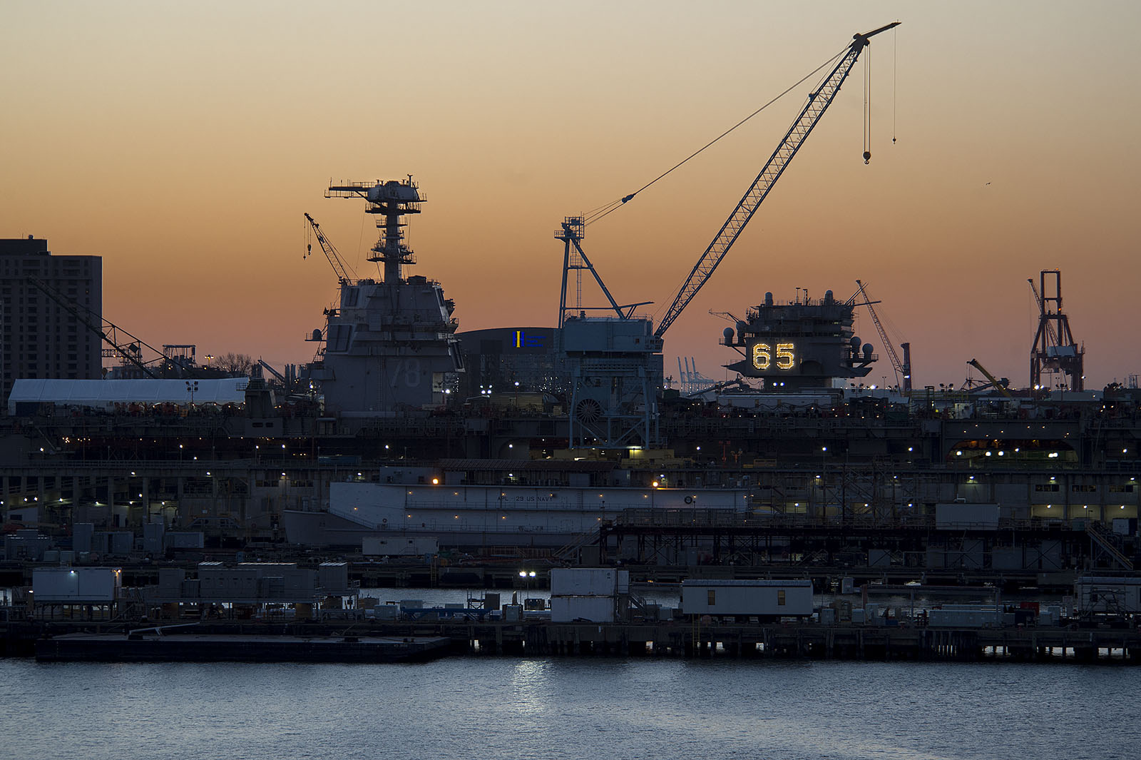 Thw aircraft carrier Gerald R Ford (CVN-78) and Enterprise (CVN-65) sit side by side in the South Yard as the sunrise starts to light up the sky. HII Photo