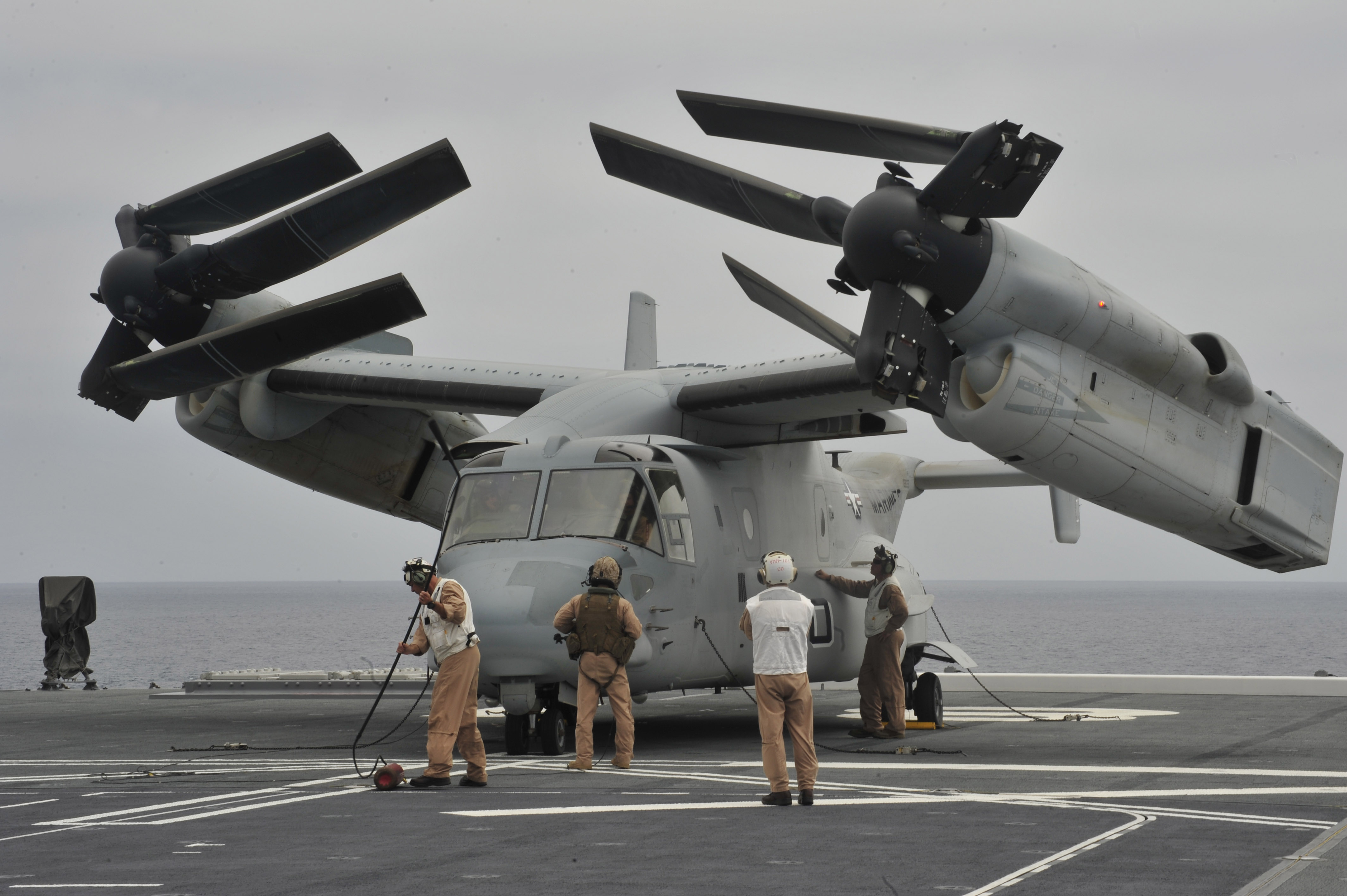 U.S. Marines inspect an MV-22 Osprey tilt-rotor aircraft after landing on the Japan Maritime Self-Defense Force helicopter destroyer JS Hyuga (DDH 181) during amphibious exercise Dawn Blitz 2014. US Navy photo.