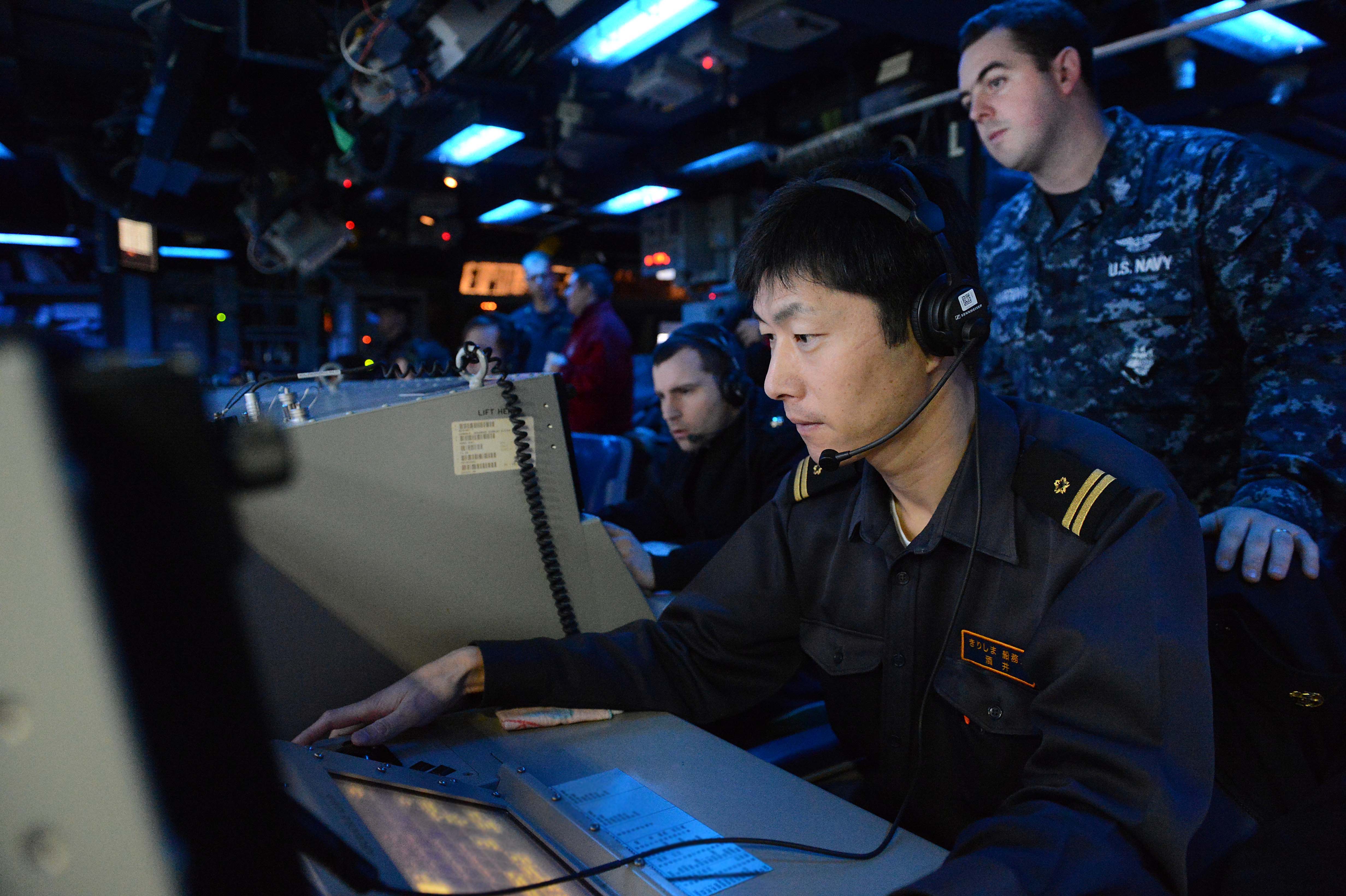 A member of the Japan Maritime Self Defense Force works inside the combat operations center of the Ticonderoga-class guided-missile cruiser USS Antietam (CG 54) on Nov. 27, 2013. US Navy Photo