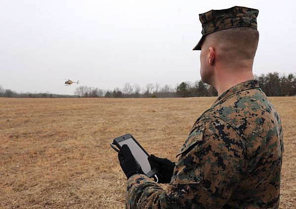 A Marine uses a handheld tablet to request resupply during an Office of Naval Research (ONR) helicopter flight demonstration with unmanned flight capability at Marine Corps Base Quantico, Va., as part of the Autonomous Aerial Cargo Utility System (AACUS) program in early 2014. US Navy Photo