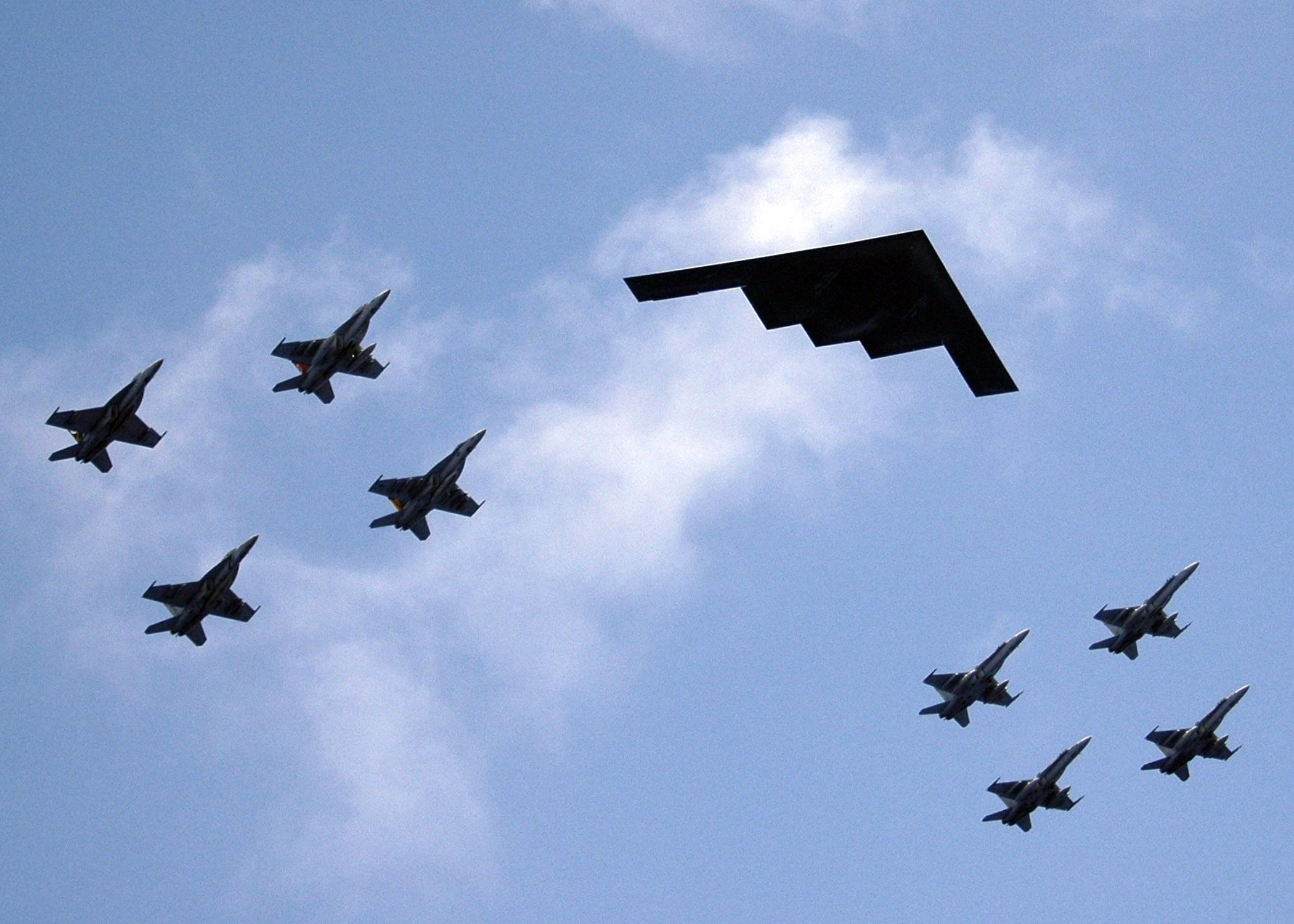 A B-2 Stealth Bomber from Whiteman AFB in Missouri leads an aerial flight formation with F-18 Hornets from the during exercise Valiant Shield 2006. US Navy Photo