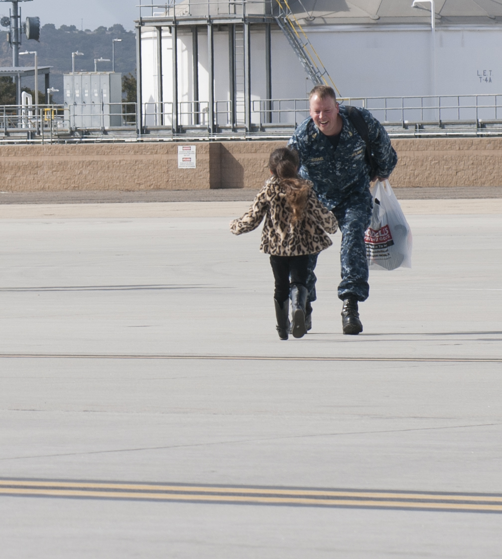 Senior Chief Information Systems Technician Dan Boemmel is greeted by his daughter after returning home from a deployment around South America. Aircraft carrier on Jan. 15, 2016. US Navy Photo