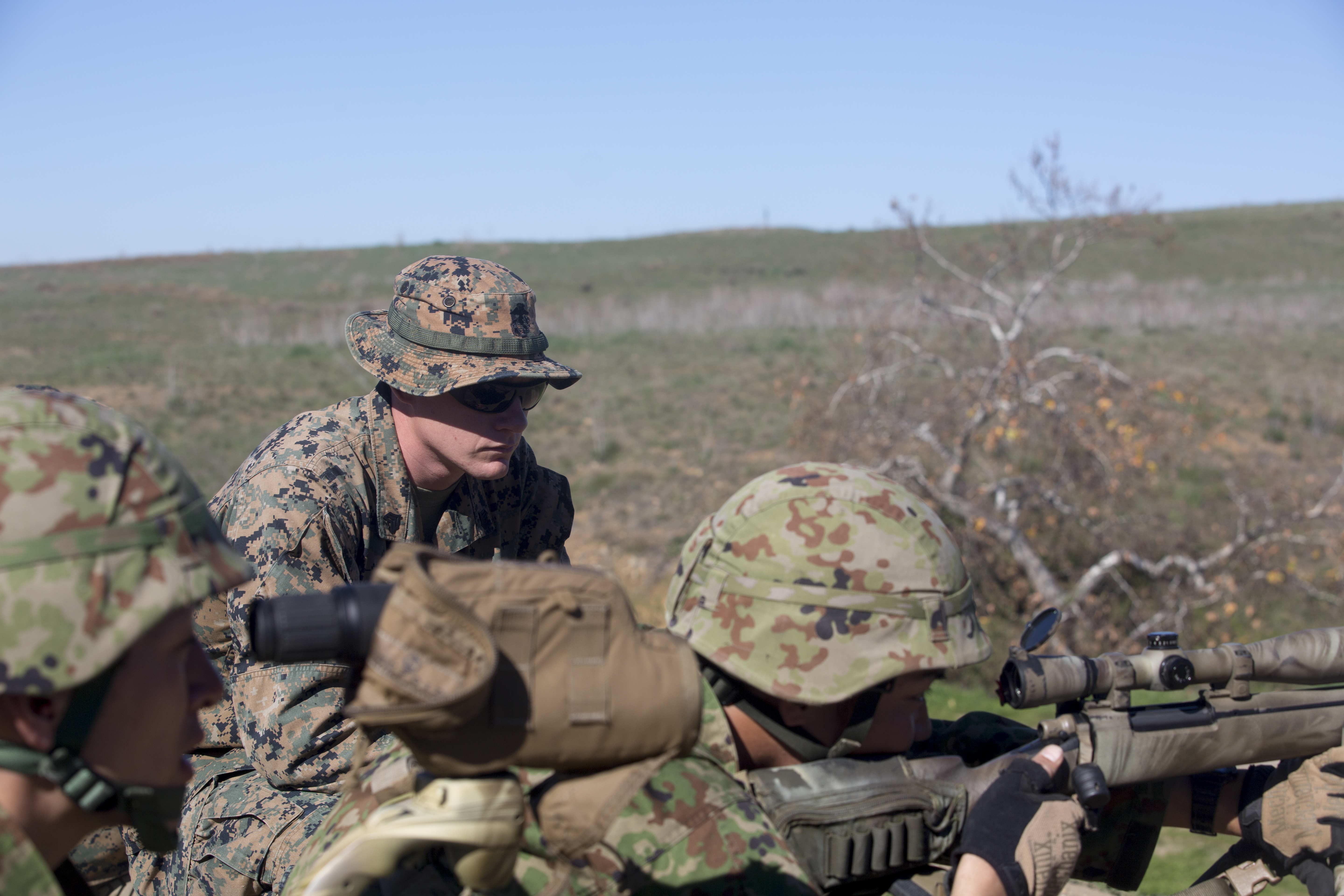 U.S. Marine Sgt. Mason Wilhelmy, primary marksmanship instructor with the Pre-Scout Sniper Course, 1st Marine Division Schools, observes the shooting form of a Japan Self-Defense Force soldier. US Marine Corps Photo