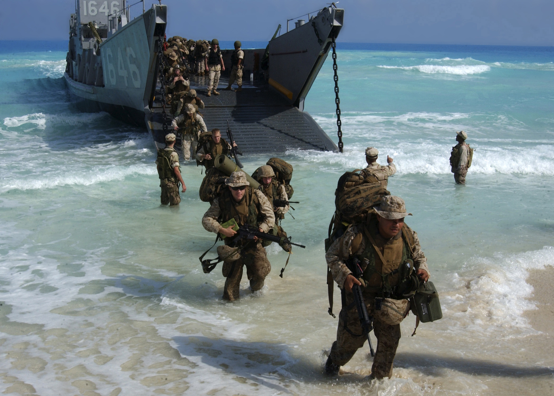 U.S. Marines from Expeditionary Strike Group One, 13th Marine Expeditionary Unit wade ashore from a landing craft. US Navy Photo 