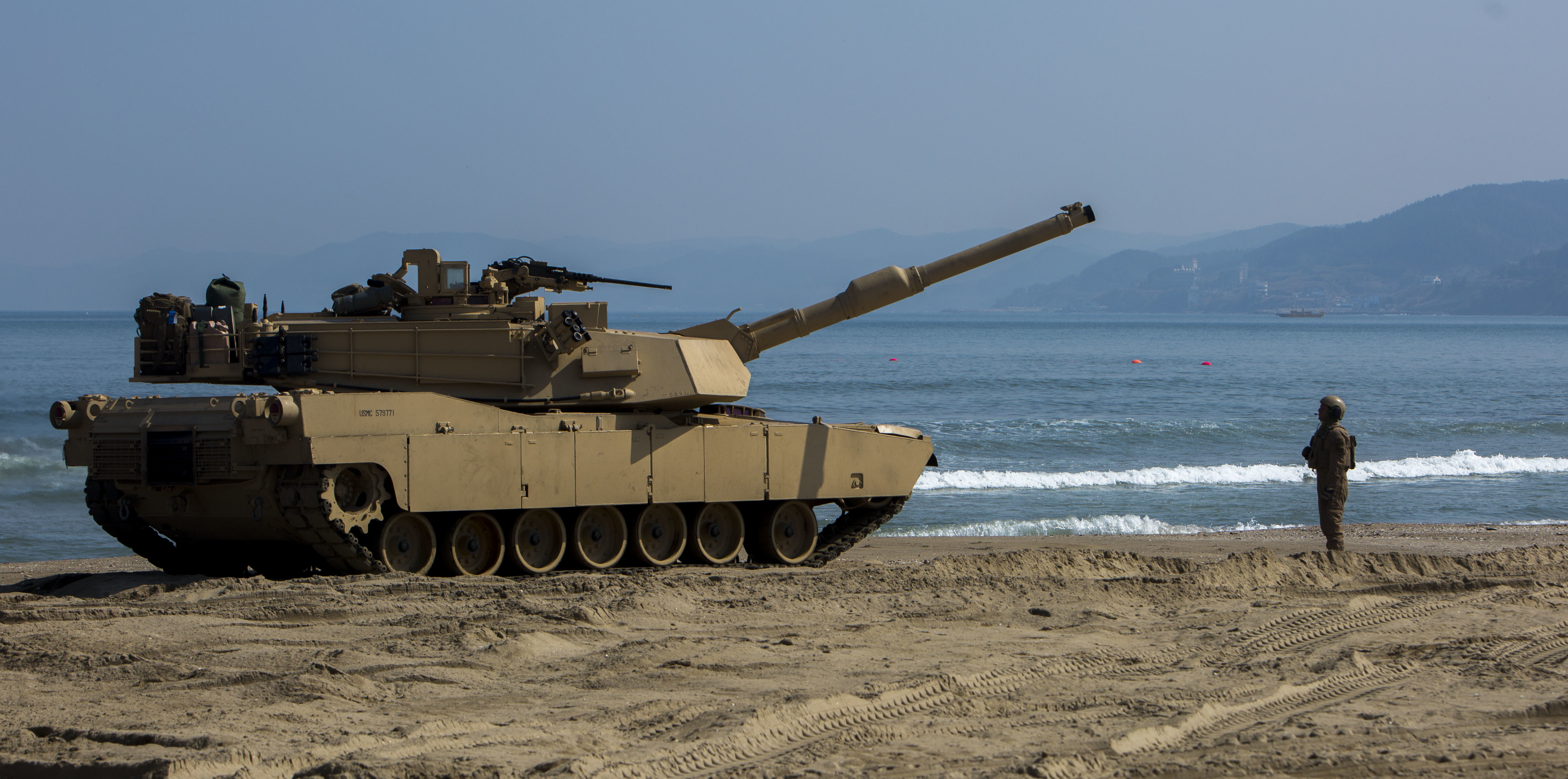 Cpl. Henry Estrada a gunner with 1st Tank Battalion from Lewisville, Texas, guides an M1A1 Abrams Main Battle Tank off the Landing Craft Air Cushion during rail operations at Dogu Beach, Republic of Korea, on March 15, 2016. US Marine Corps Photo