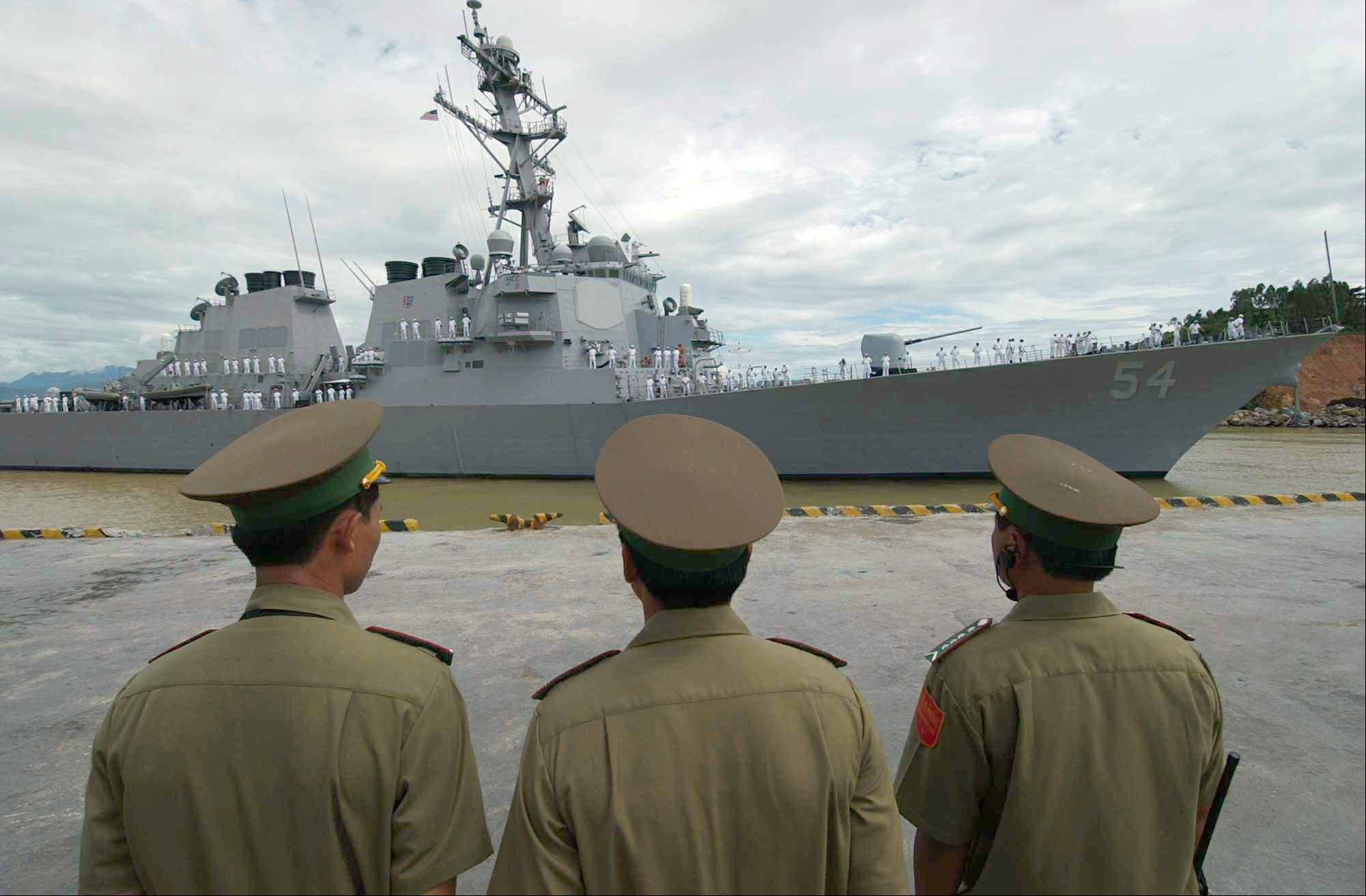 Vietnamese military officials watch as USS Curtis Wilbur (DDG-54) prepares to moor in the Vietnamese port of Da Nang. US Navy Photo