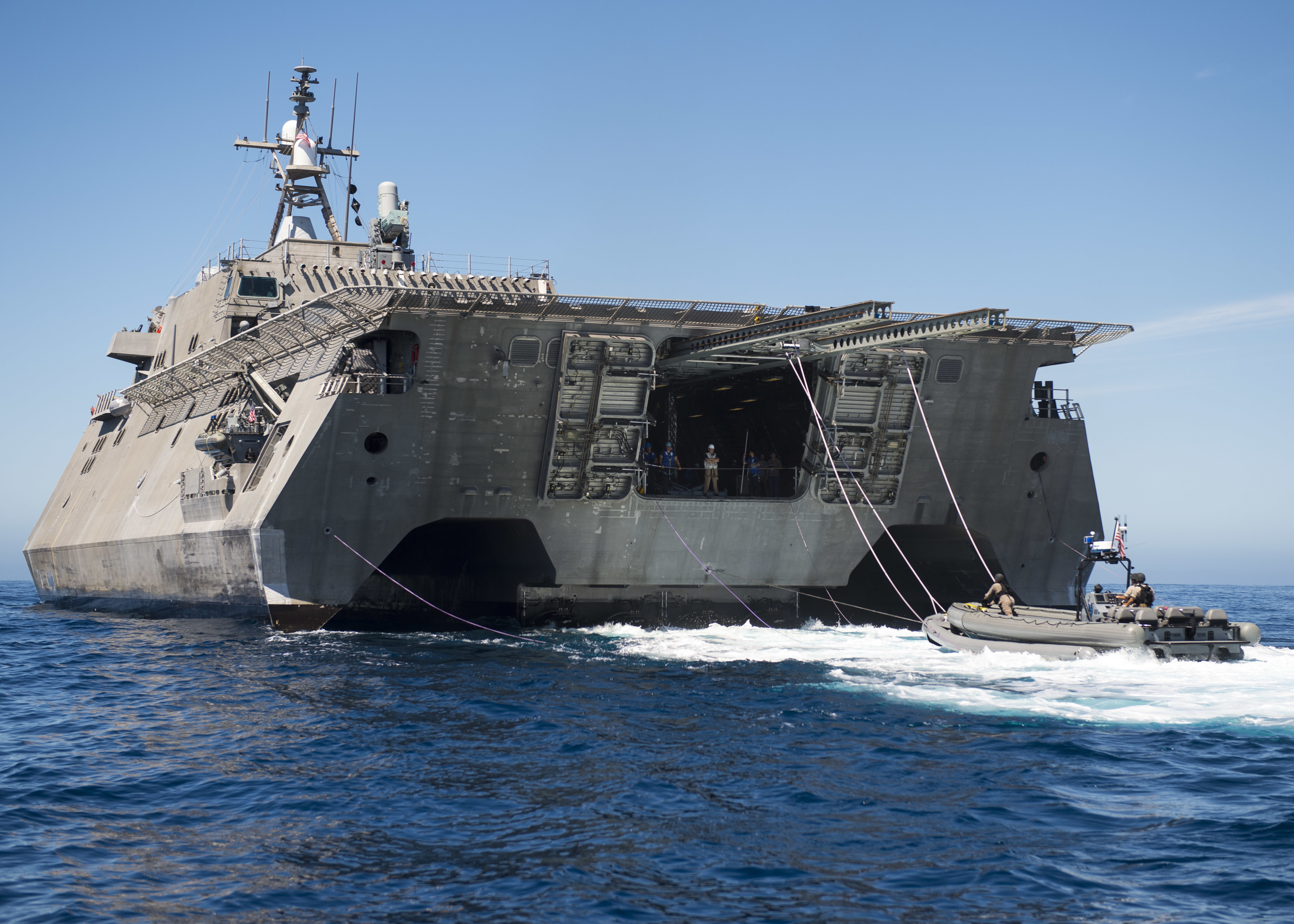 Sailors assigned to Surface Warfare Mission Package Detachment 2 prepare to be hoisted out of the water by the littoral combat ship USS Coronado's (LCS 4) twin-boom-extensible crane following a visit, board, search and seizure training exercise on Aug. 15, 2015. US Navy photo.