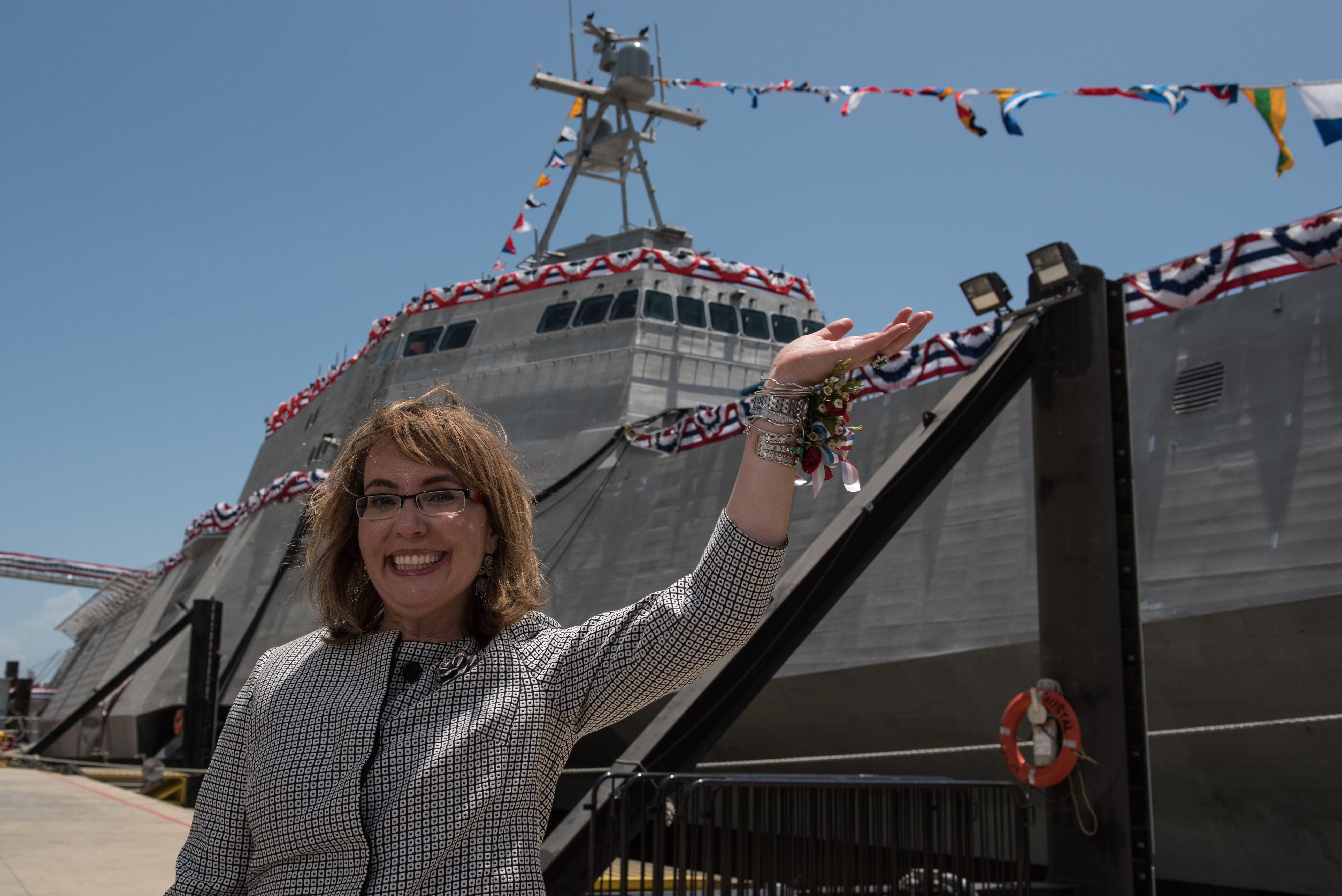 Former U.S. Rep. Gabrielle Giffords waves to a crowd in front of the littoral combat ship, USS Gabrielle Giffords (LCS 10), during the ship's christening ceremony on June 13, 2015. US Navy photo.