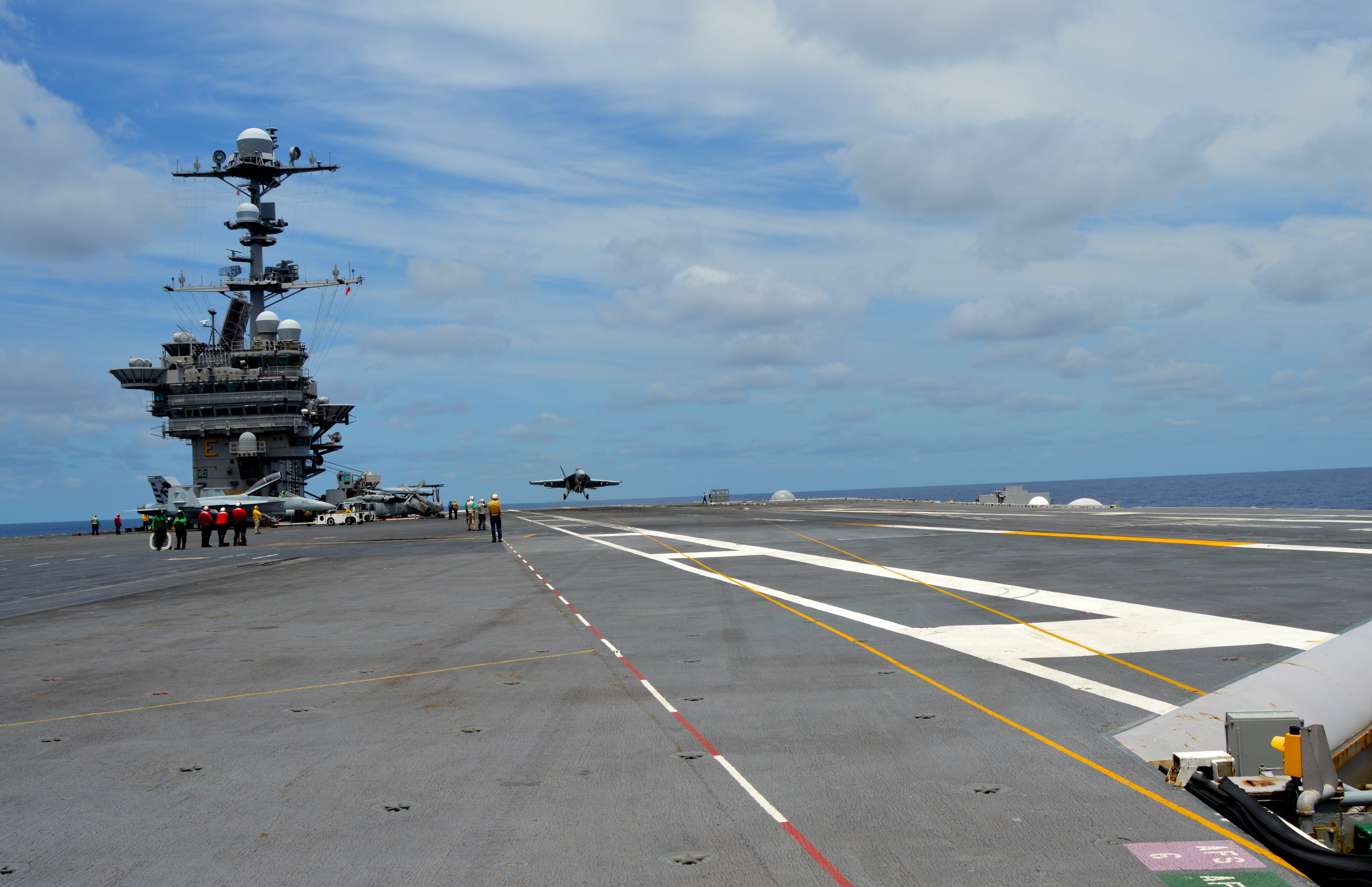 An F/A-18F Super Hornet in Air Test and Evaluation Squadron (VX) 23 conducts touch-and-go flight operations off the deck of USS George Washington (CVN-73) on June 27, 2016, while testing the MAGIC CARPET carrier landing assistance technology. USNI News photo.