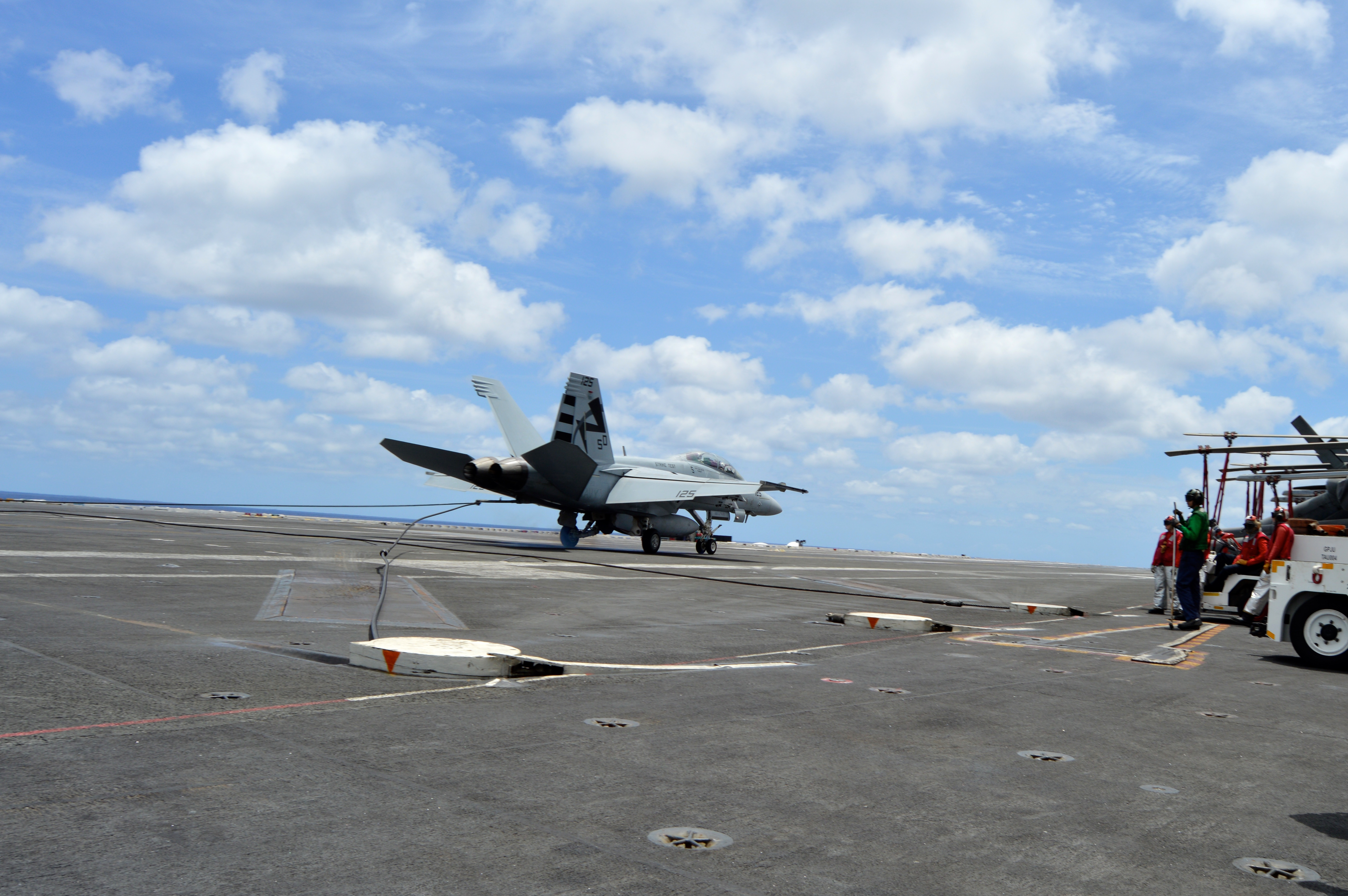 A F/A-18F Super Hornet catches the arresting gear wire while landing aboard USS George Washington (CVN-73) on June 27, 2016, while testing the MAGIC CARPET carrier landing assistance technology. USNI News photo.