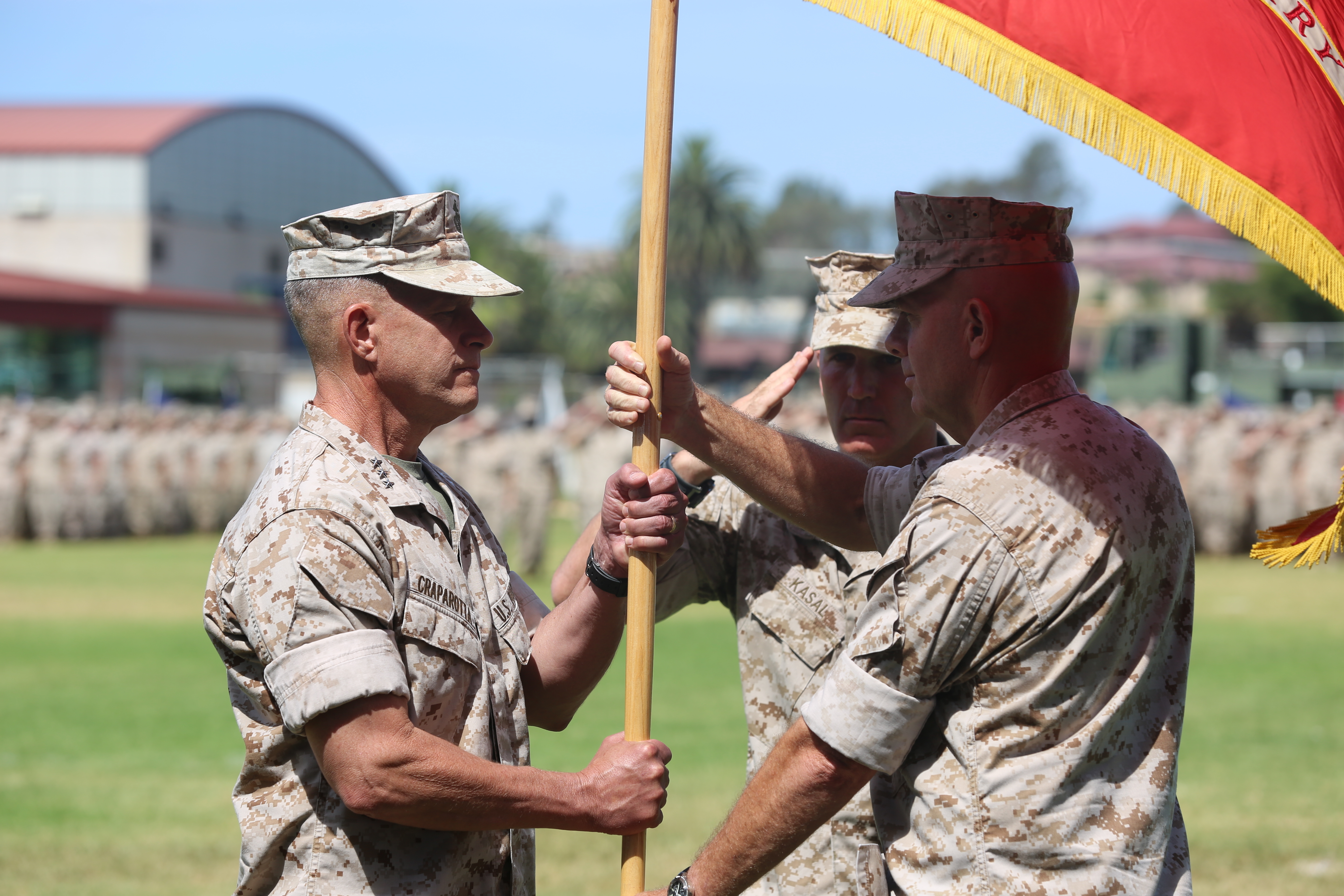 Lt. Gen. David H. Berger, the outgoing commanding general of I Marine Expeditionary Force, passes the unit colors to Lt. Gen. Lewis A. Craparotta during a change of command ceremony at Camp Pendleton on July 27, 2016. US Marine Corps Photo