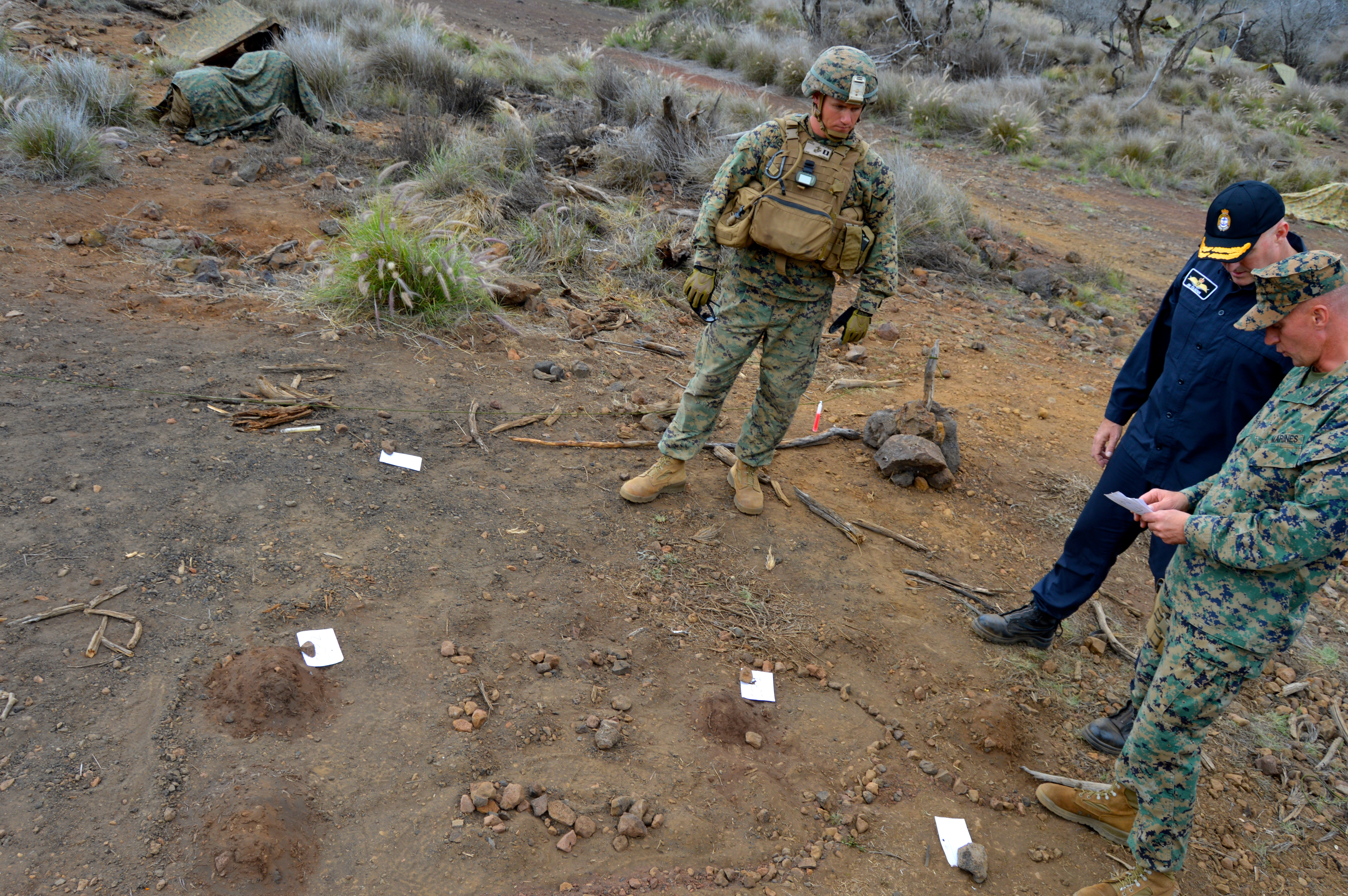 U.S. Marines explain the Range 10 Combat Infantry Battle Course using a small-scale map on the ground to Commodore James Gilmour, New Zealand’s Maritime Component Commander who leads the amphibious Task Force 176 during the Rim of the Pacific 2016 exercise. USNI News photo.