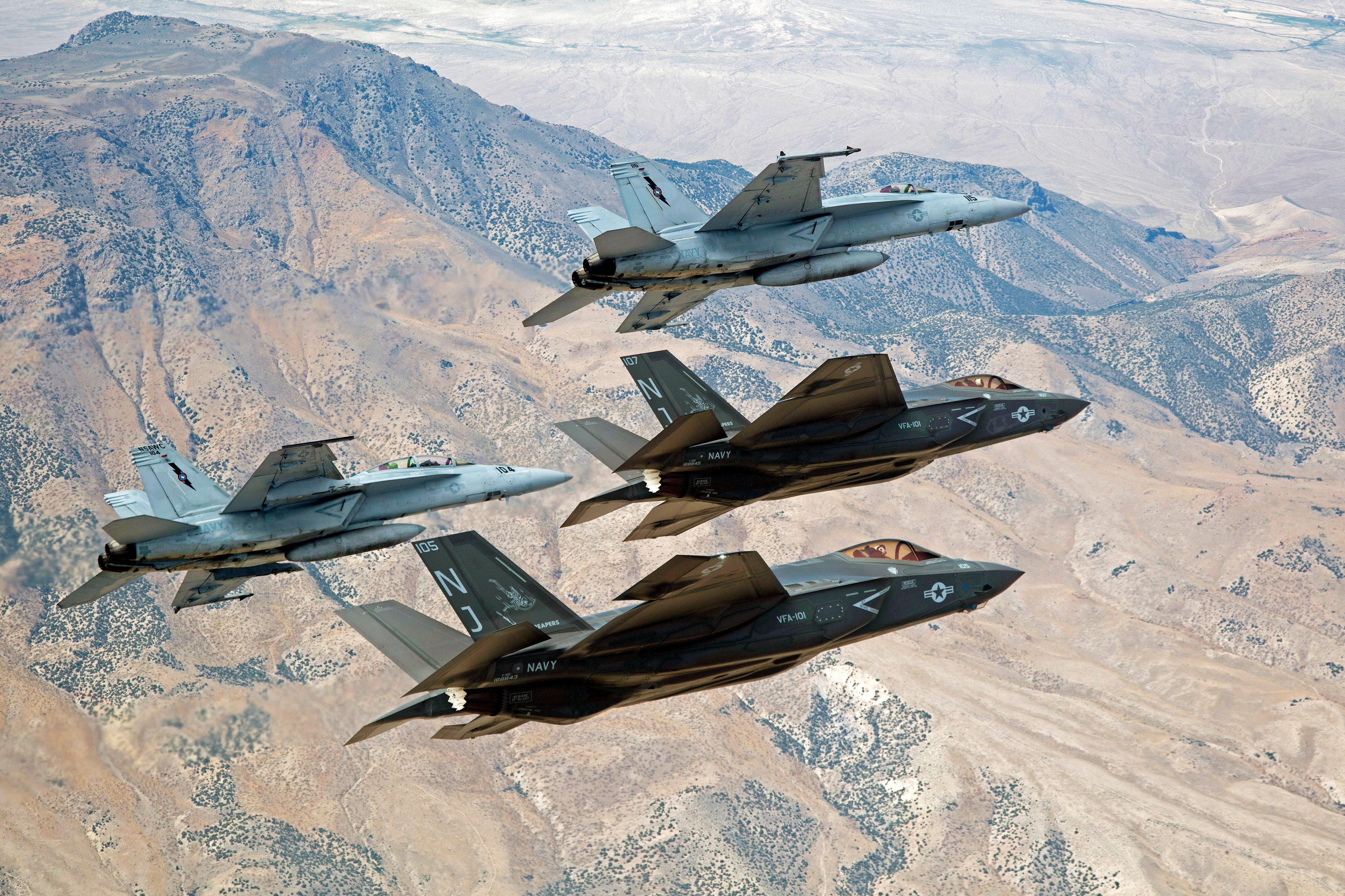 F-35C Lightning IIs, attached to the Grim Reapers of Strike Fighter Squadron (VFA) 101, and an F/A-18E/F Super Hornets attached to the Naval Aviation Warfighter Development Center (NAWDC) fly over Naval Air Station Fallon's (NASF) Range Training Complex on Sept. 3, 2015. US Navy photo.