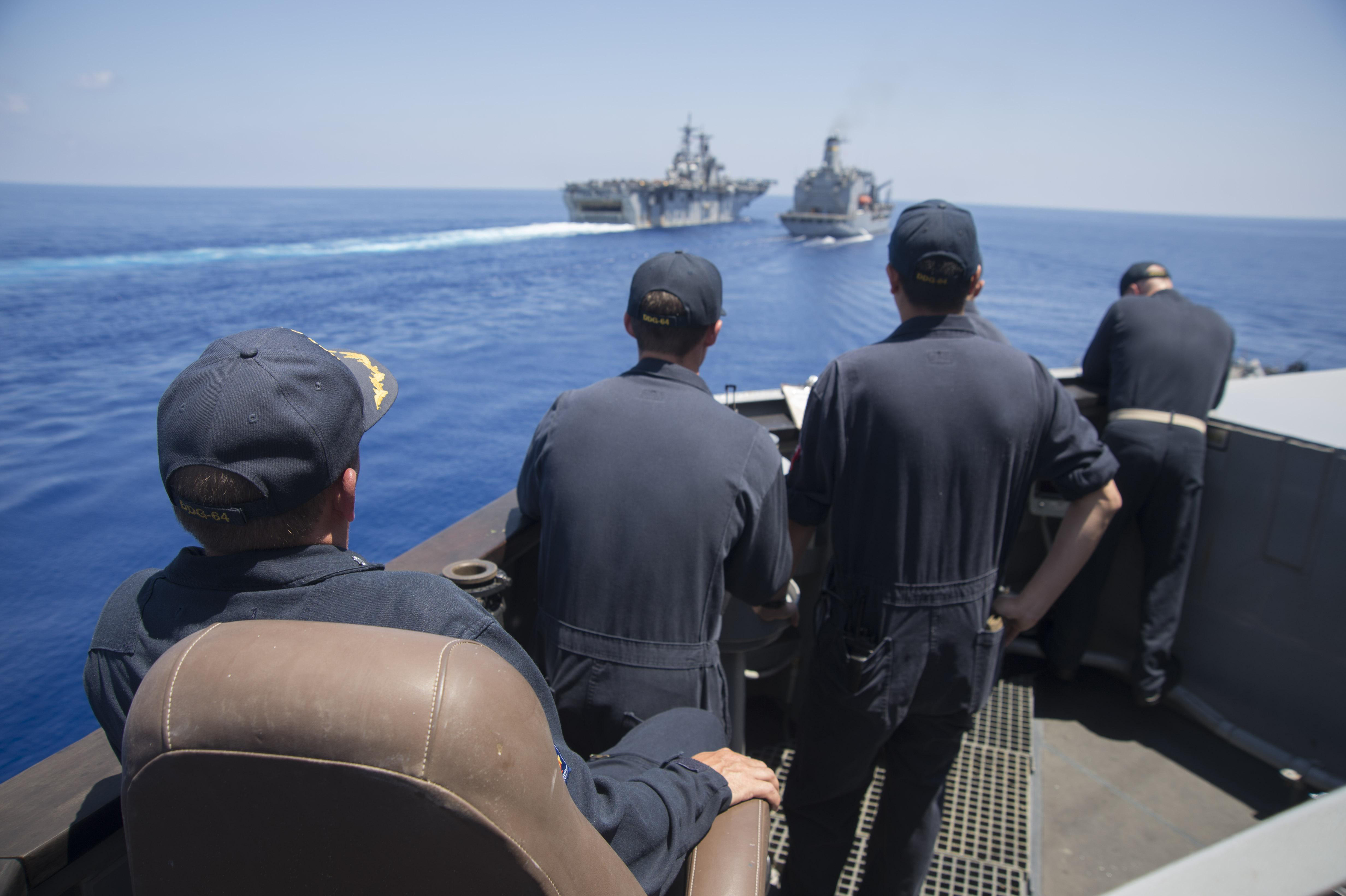 USS Carney (DDG-64) commanding officer Cmdr. Ken Pickard watches the approach to the Military Sealift Command fleet replenishment oiler USNS Big Horn (T-AO-198) and USS Wasp (LHD 1) during a replenishment-at-sea in the Mediterranean Sea on Aug. 6, 2016. US Navy photo.