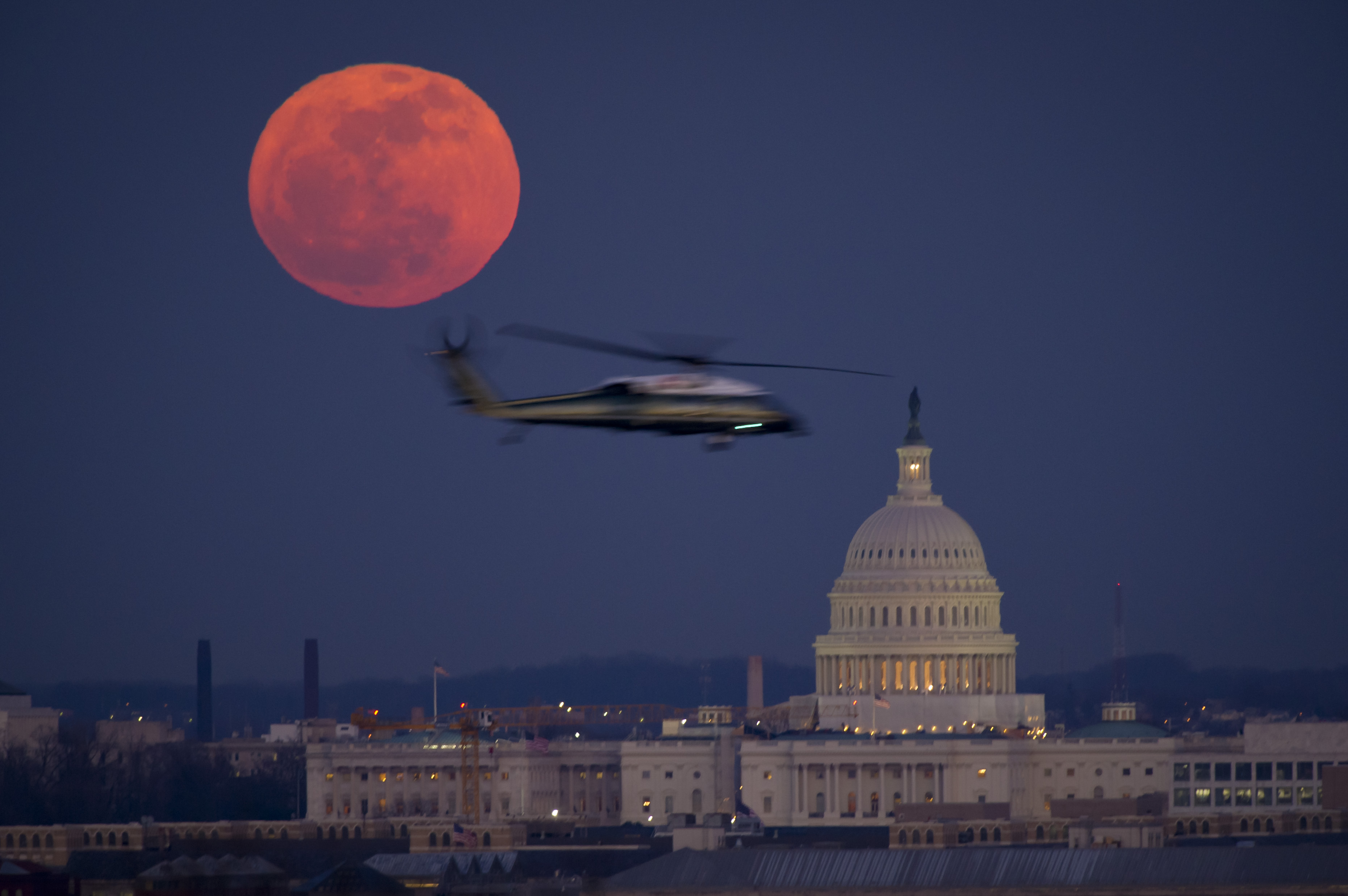 A United States Marine Corps helicopter is seen flying through this scene of the full Moon and the U.S. Capitol on Tuesday, Feb. 7, 2012 from Arlington National Cemetery. Photo Credit: (NASA/Bill Ingalls)